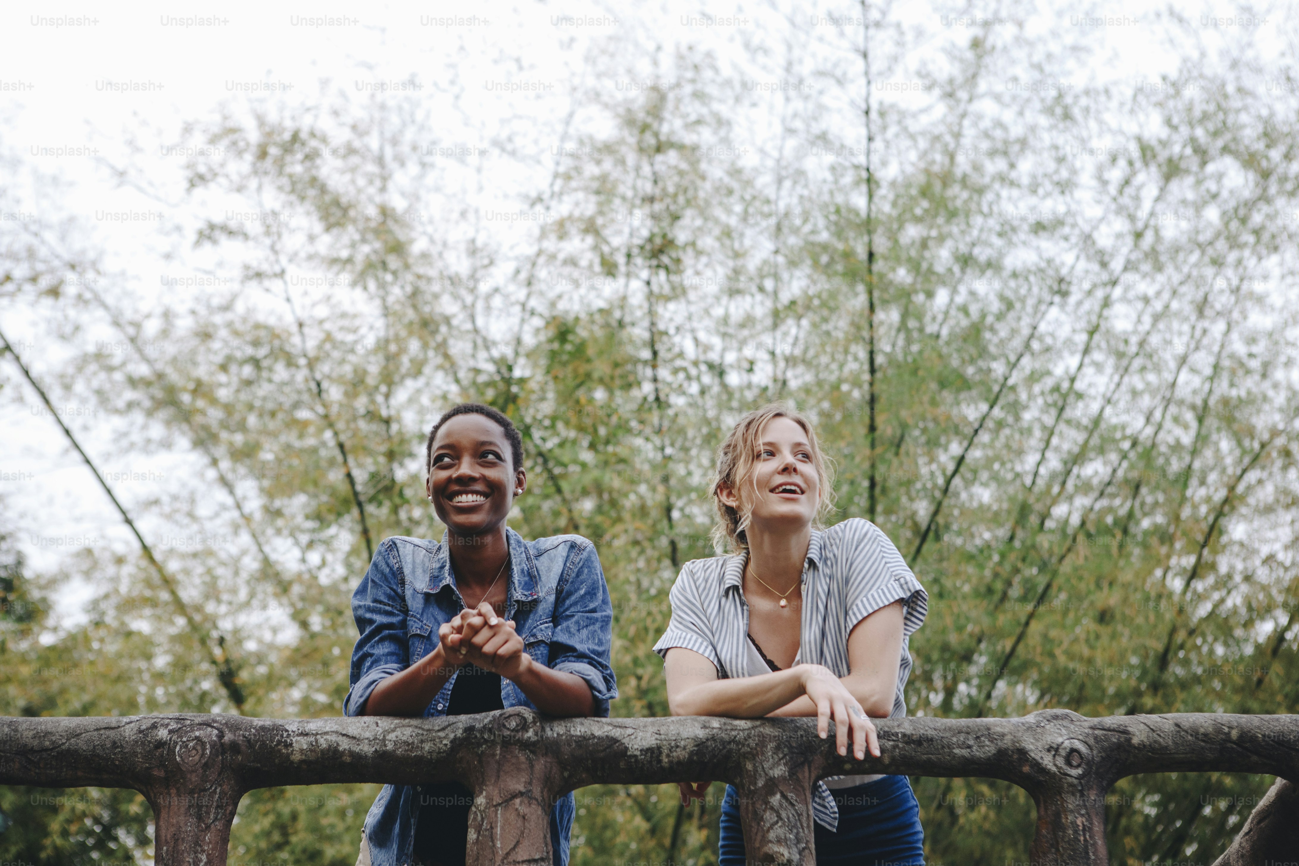 Two young female adult friends outdoors friendship bonding, freedom and outdoor concept