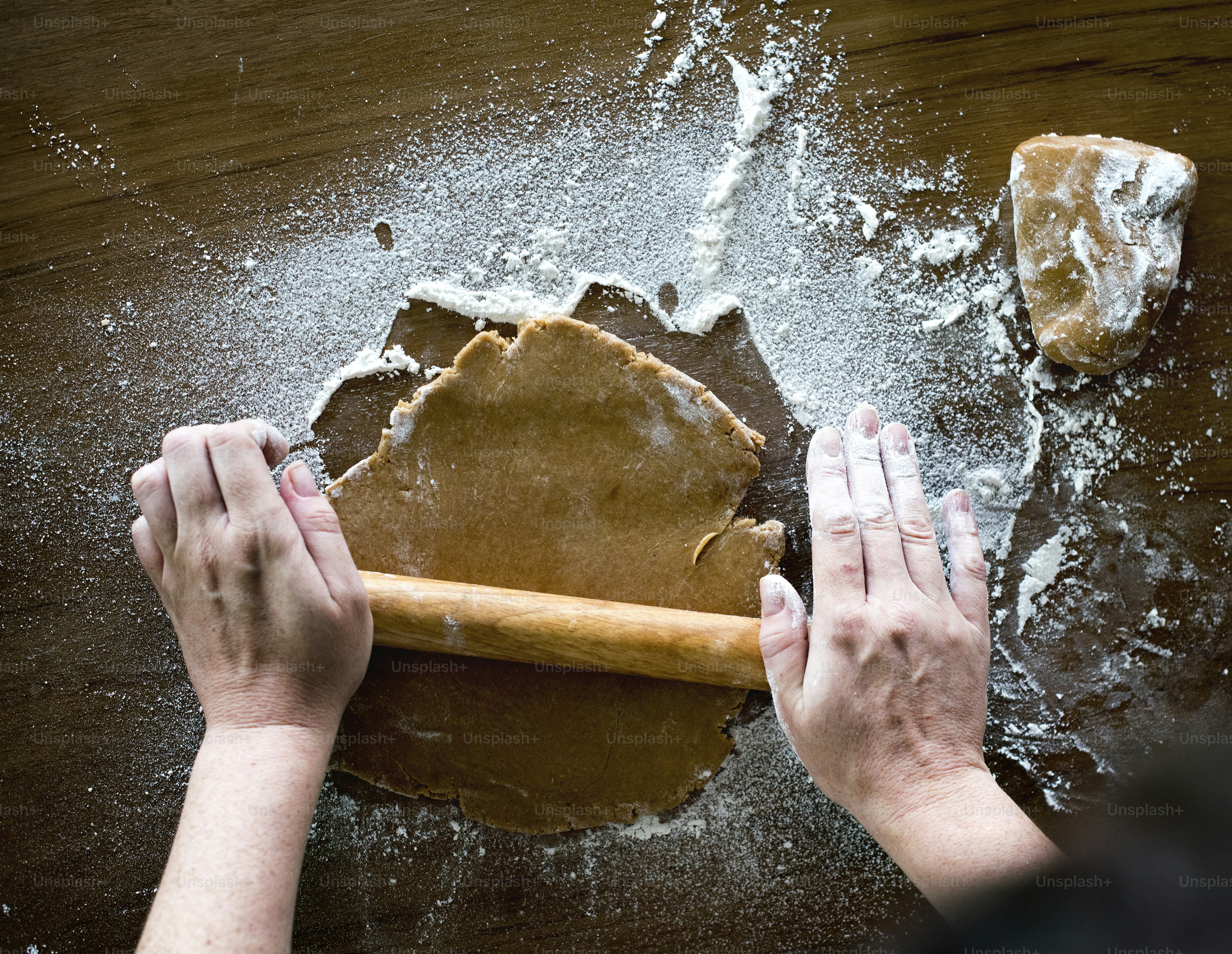 Woman flattening gingerbread cookie dough