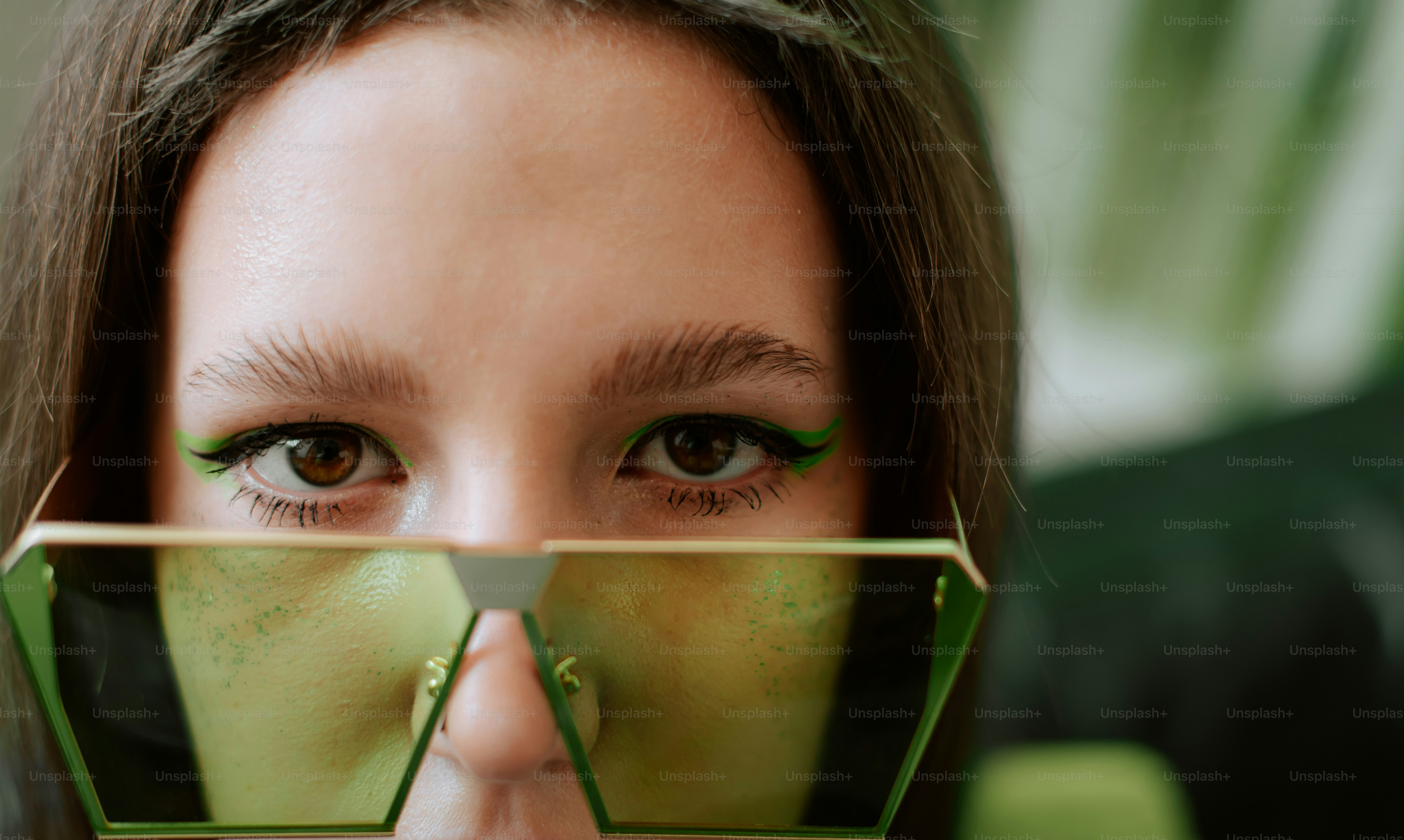 Une femme tenant une paire de lunettes devant son visage