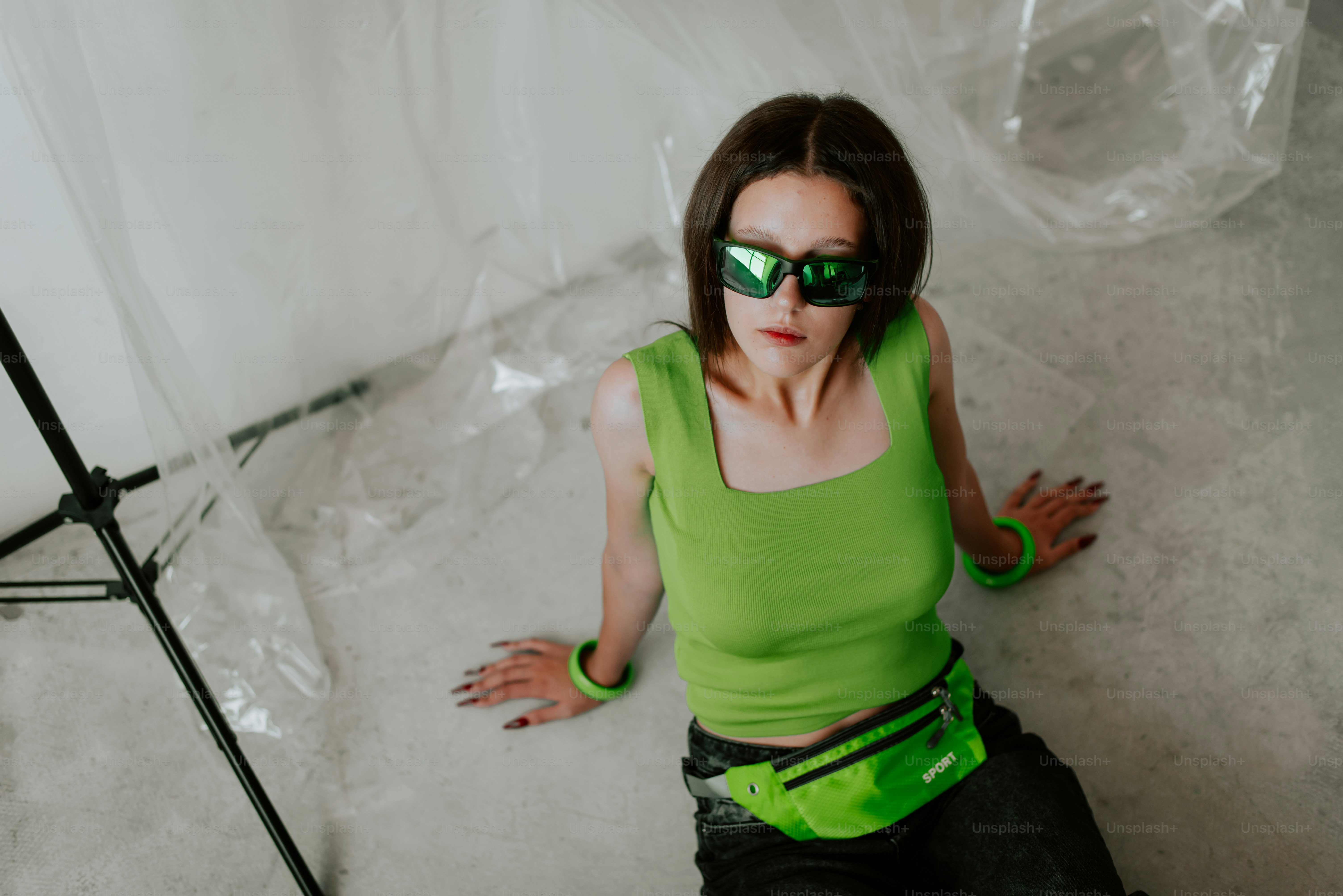 Une femme en chemise verte et lunettes de soleil