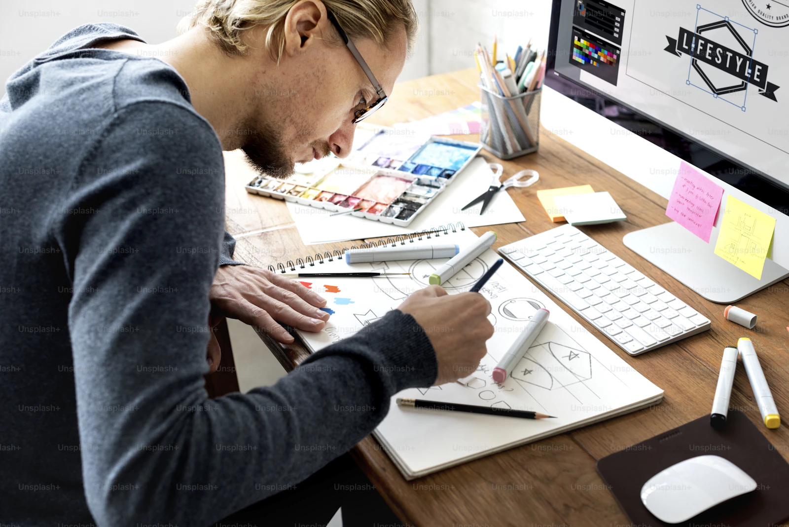 Landscape technology-themed stock image showing a designer at work in a modern studio environment — Photo by Unsplash