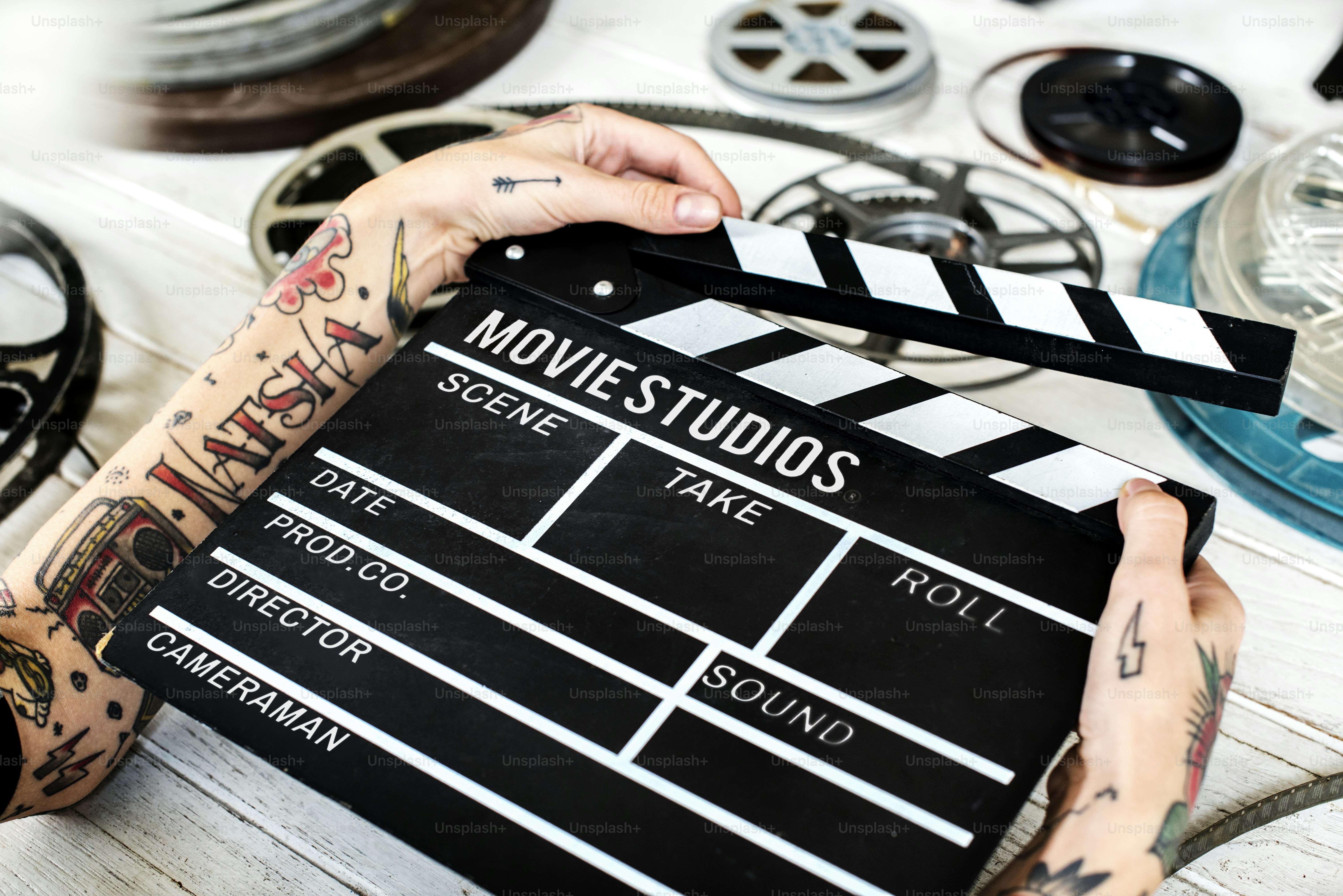 Hands with tattoo holding a slate