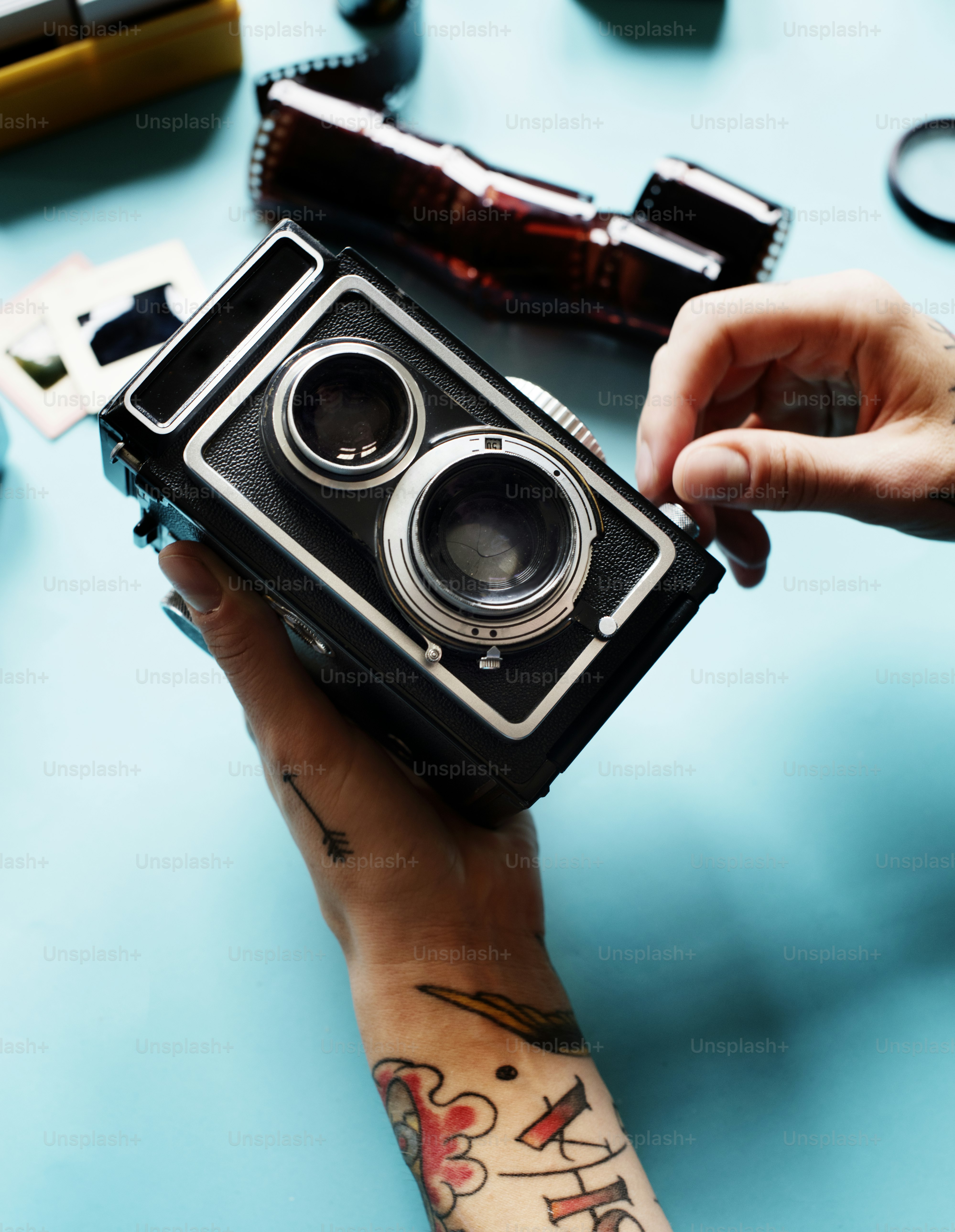 Hands with tattoo holding a camera