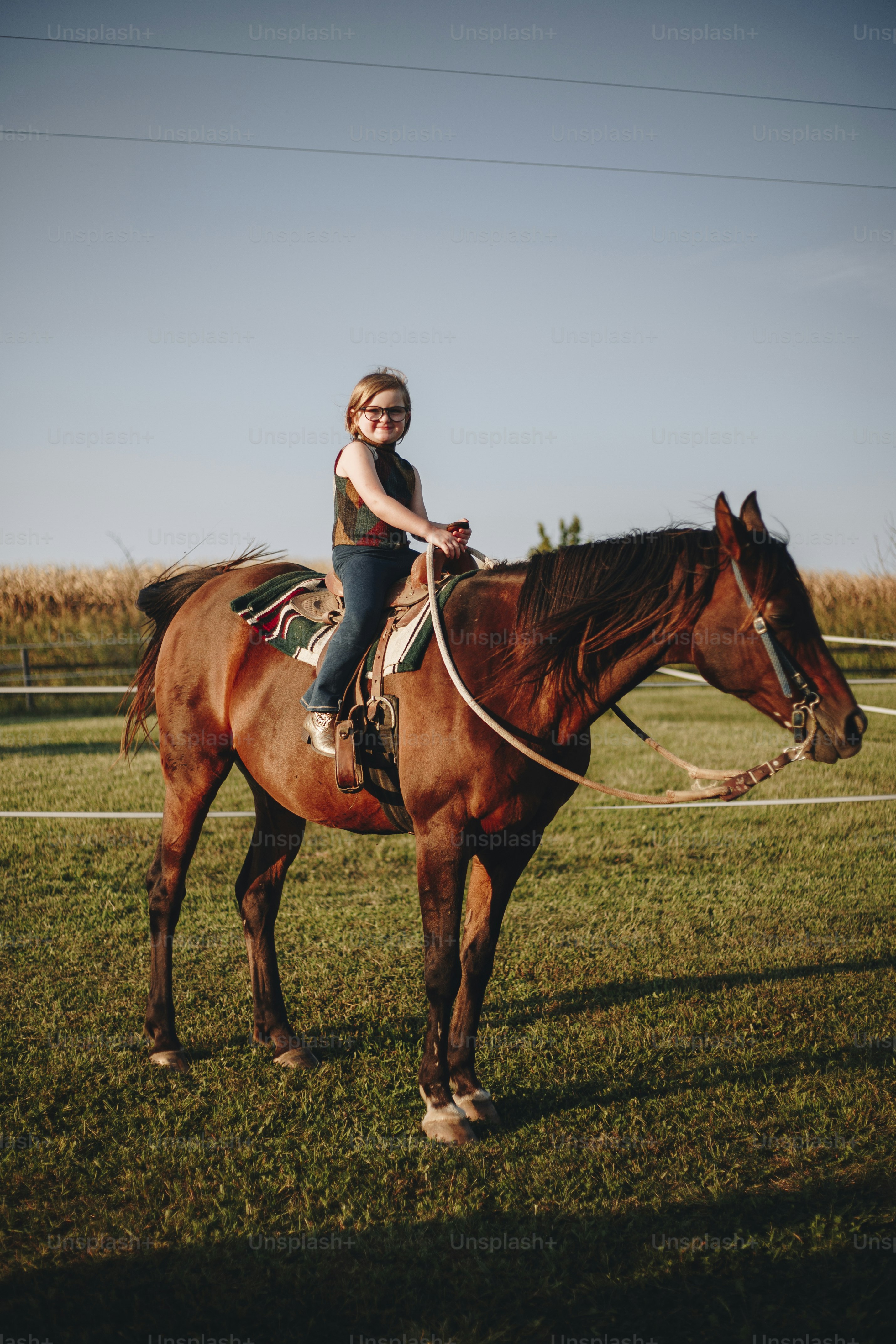 若い女の子は乗馬を楽しんでいます