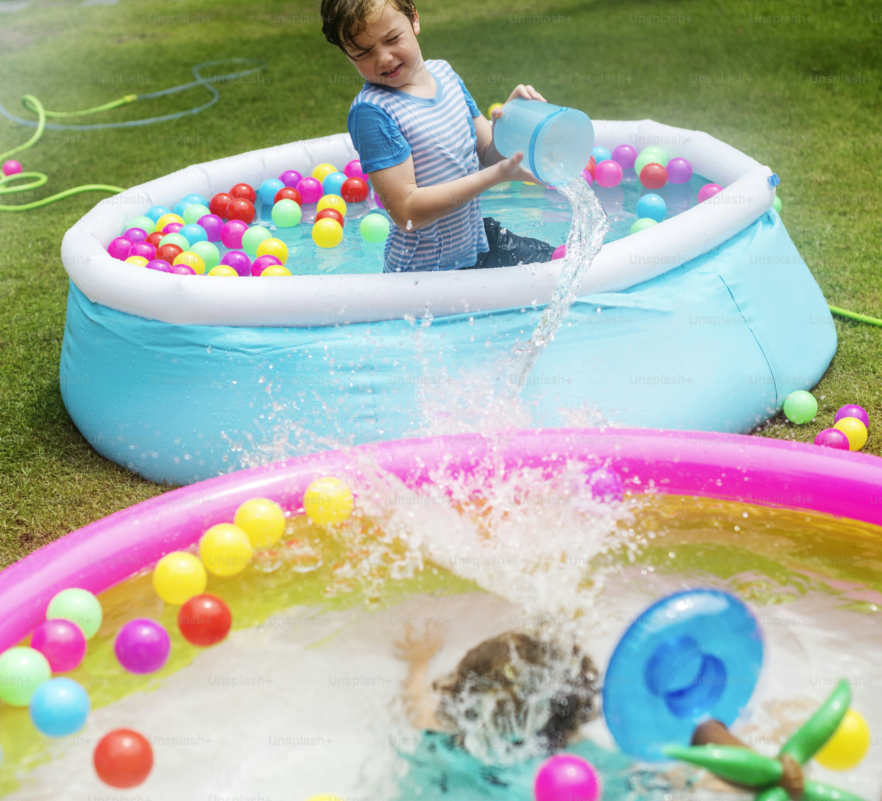 Young caucasian boy in inflatable pool enjoying water