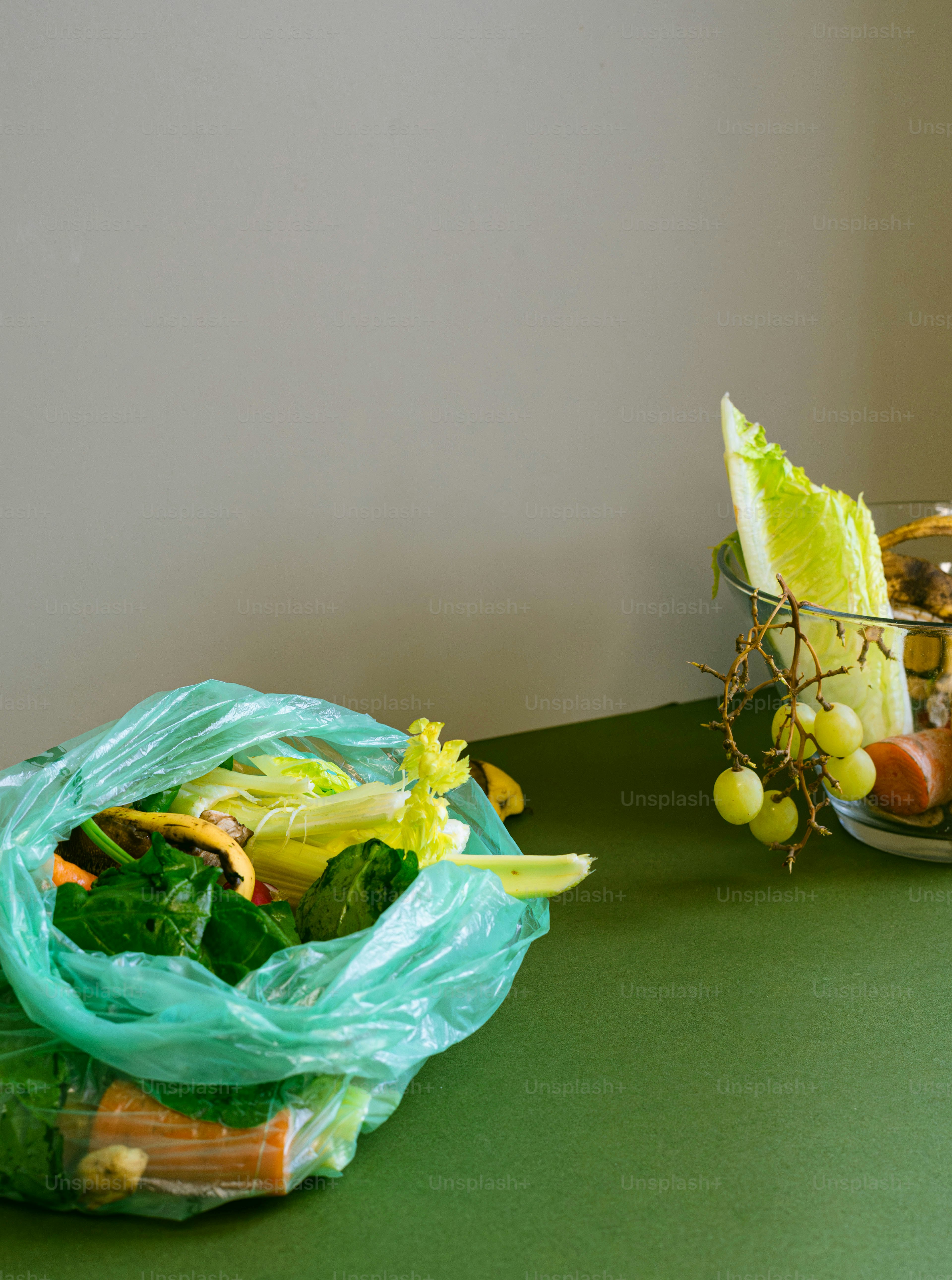 Una mesa verde cubierta con un cuenco de frutas y verduras