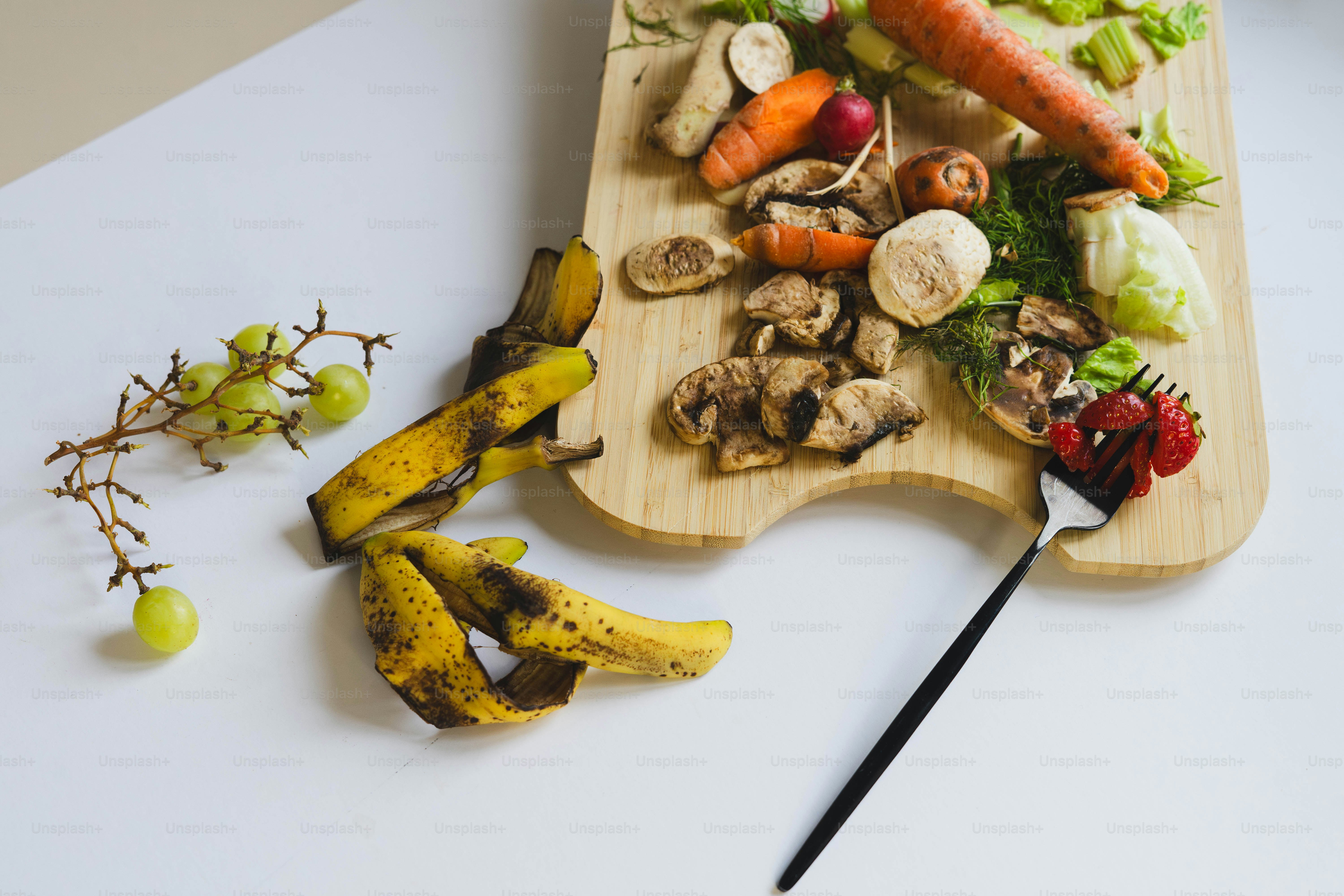 Una tabla de cortar de madera cubierta con verduras y champiñones