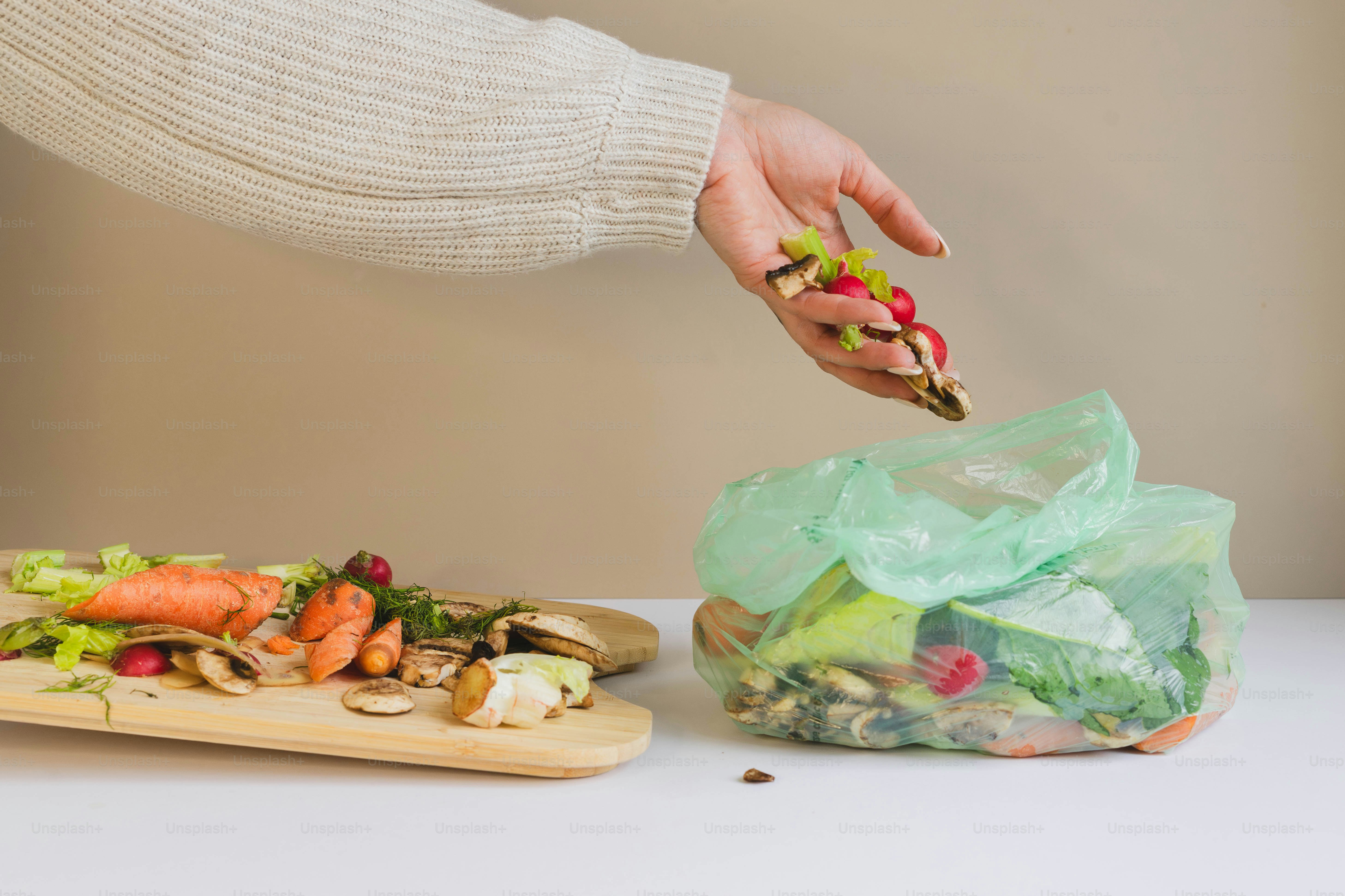 A woman is picking up a piece of food from a bag