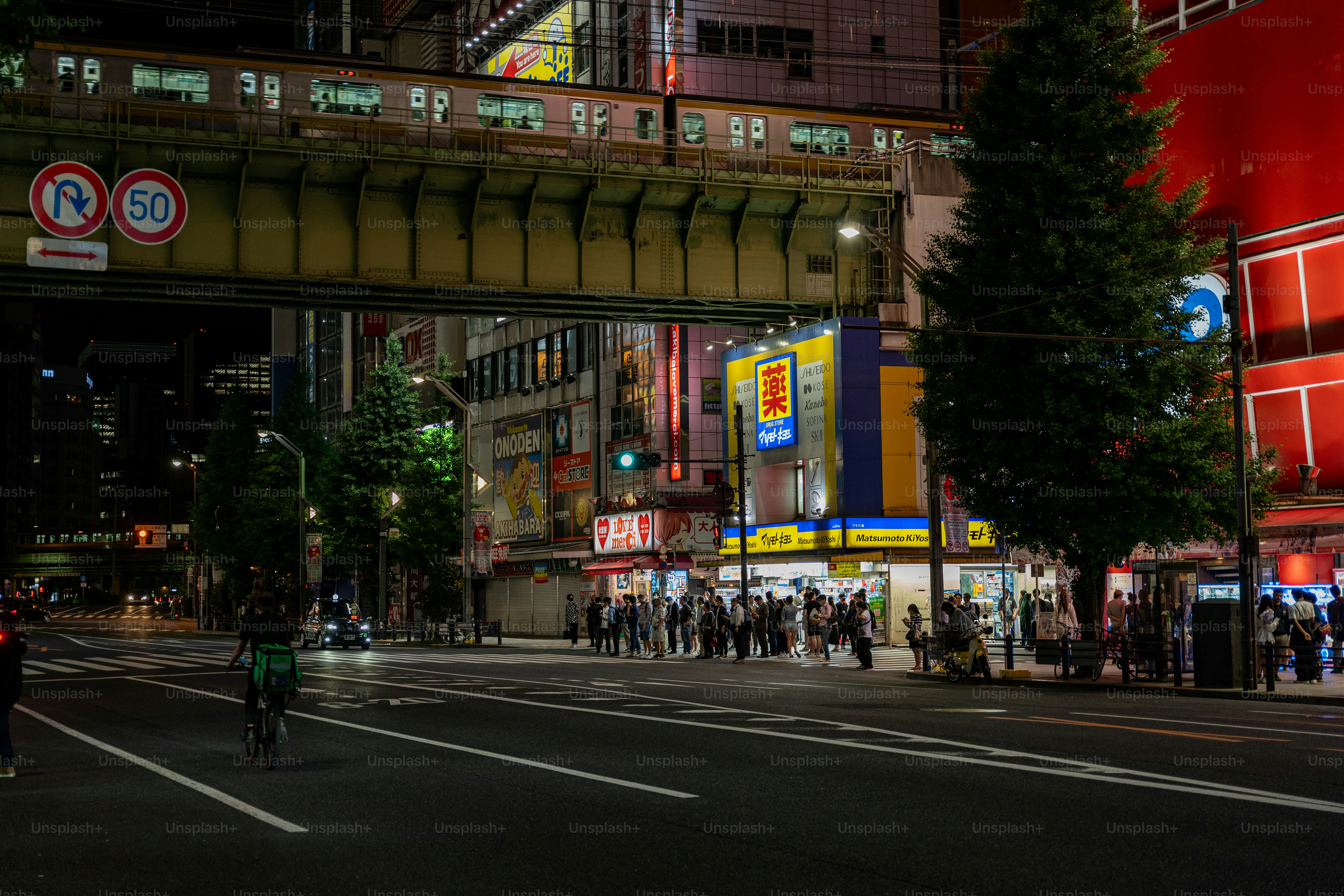 A group of people walking down a street next to tall buildings