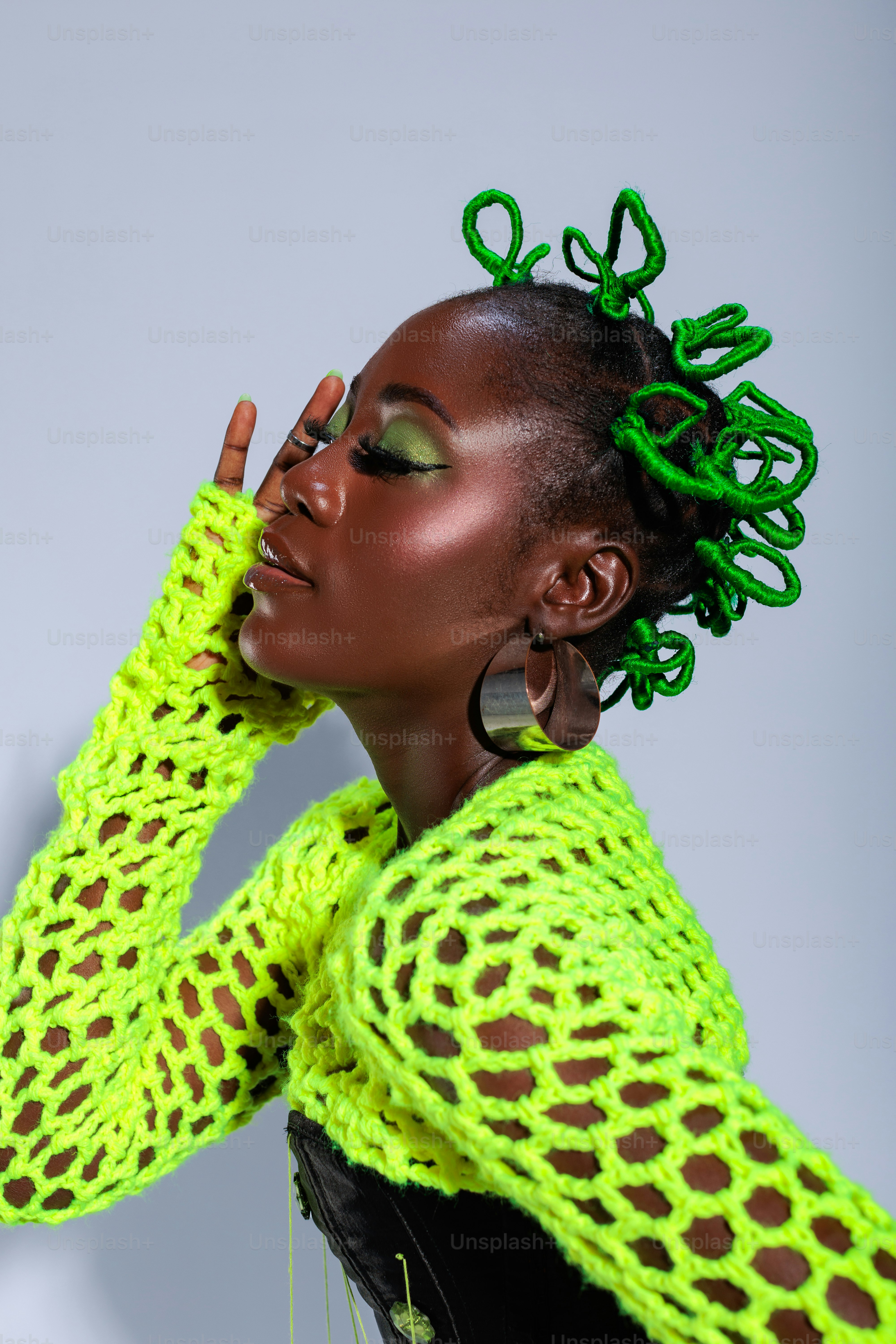 A woman with green hair wearing a neon green sweater