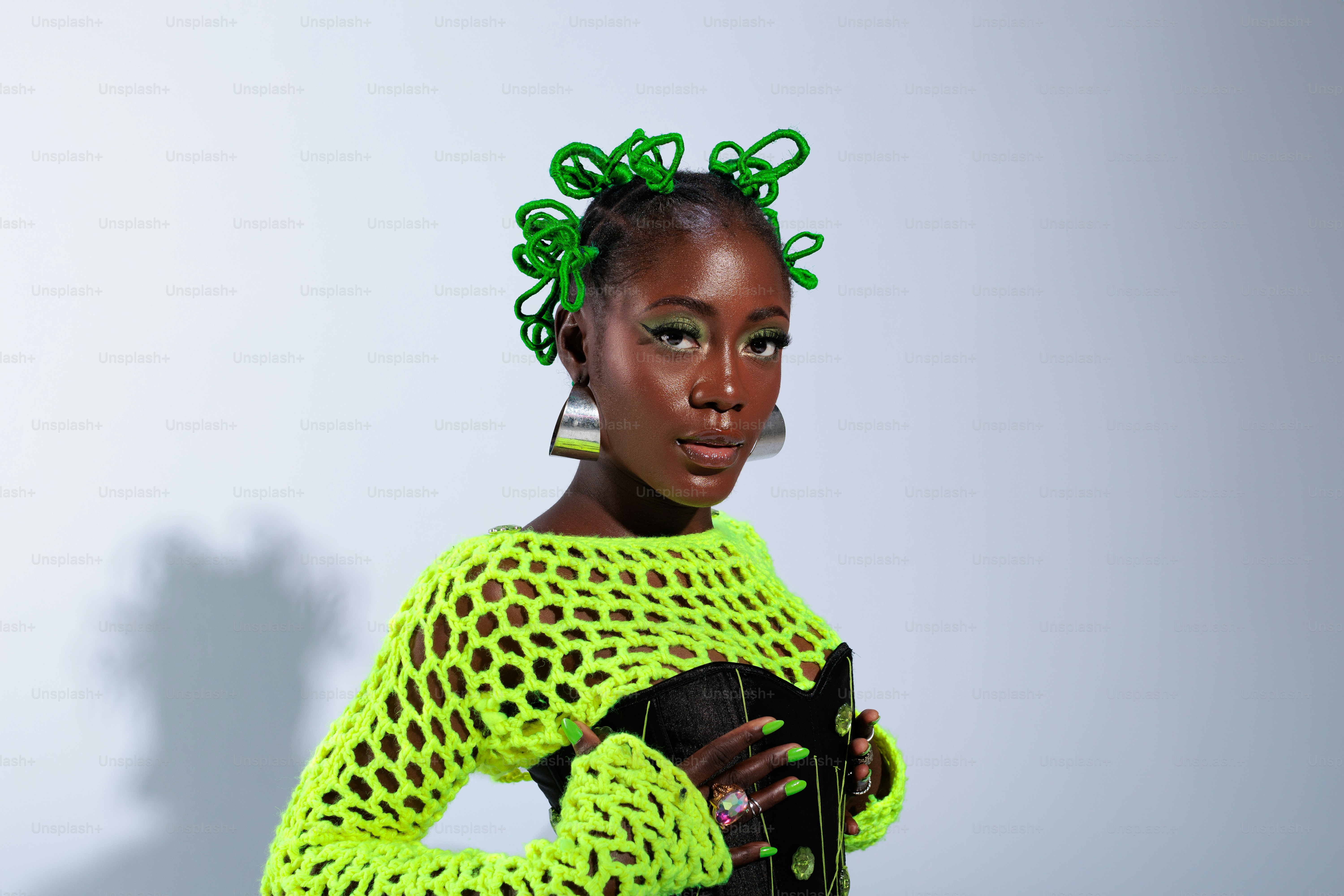 ネオングリーンのセーターを着てカメラを持つ女性