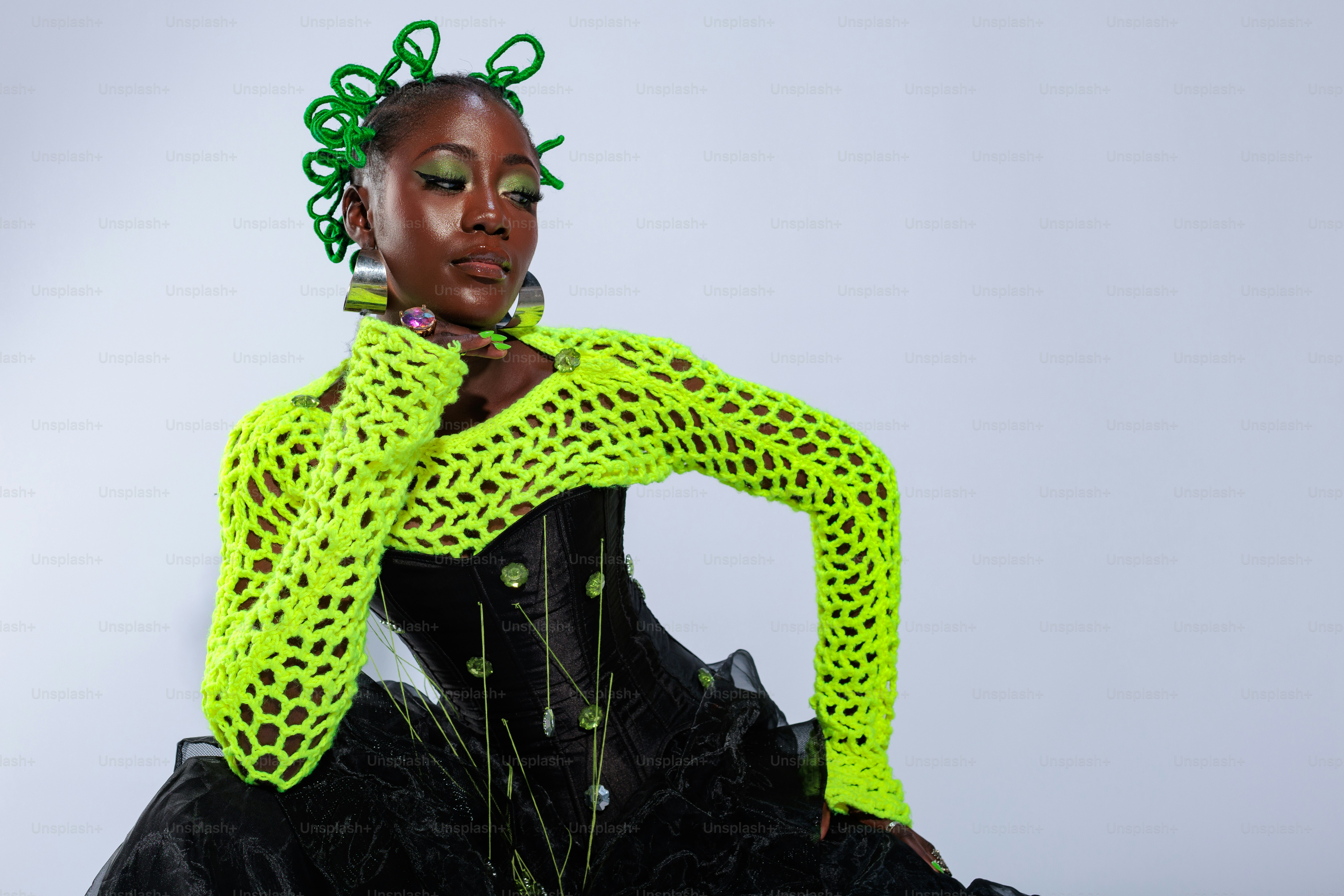 A woman with green hair sitting on the ground