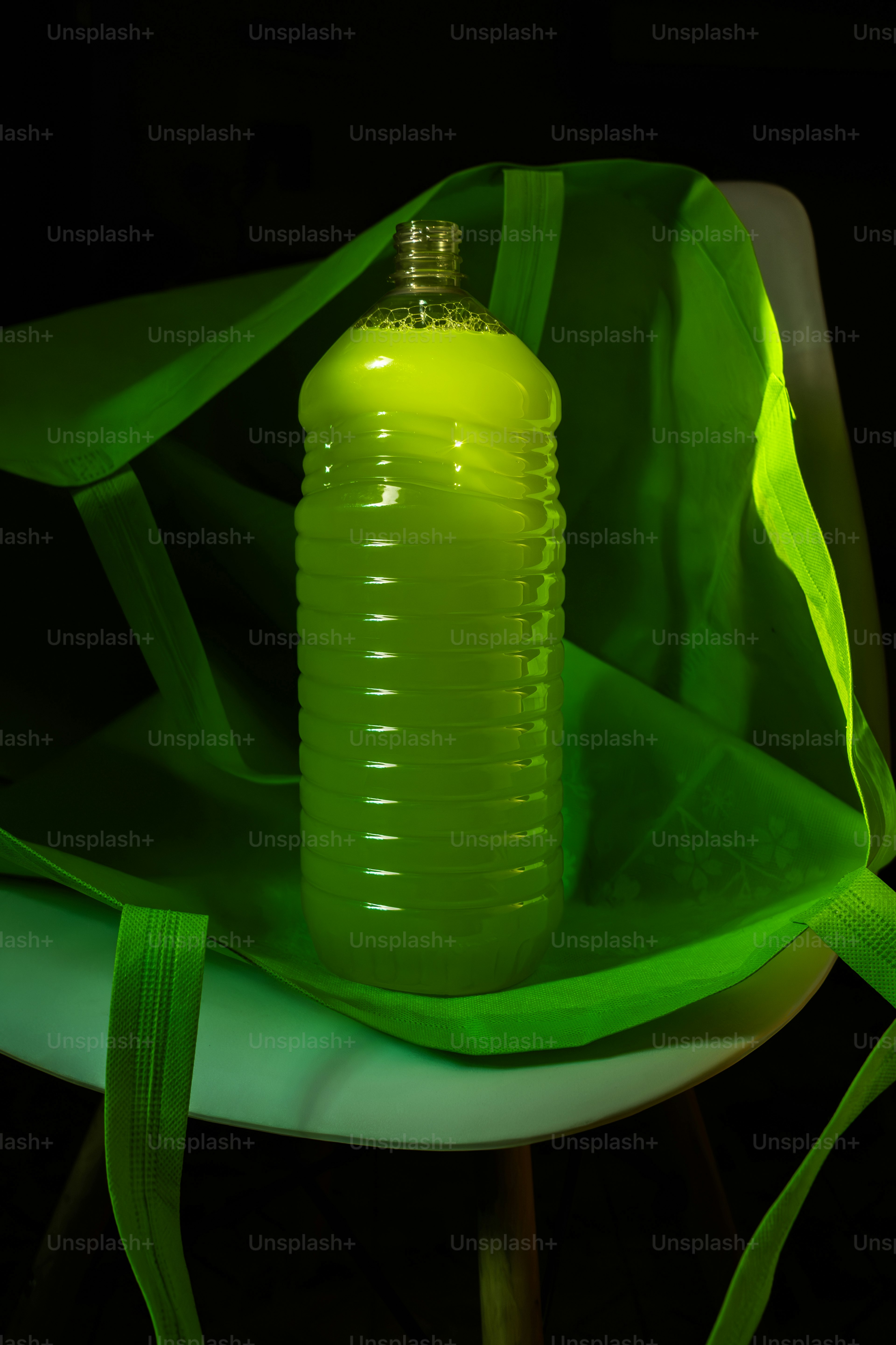 A green bottle sitting on top of a white plate