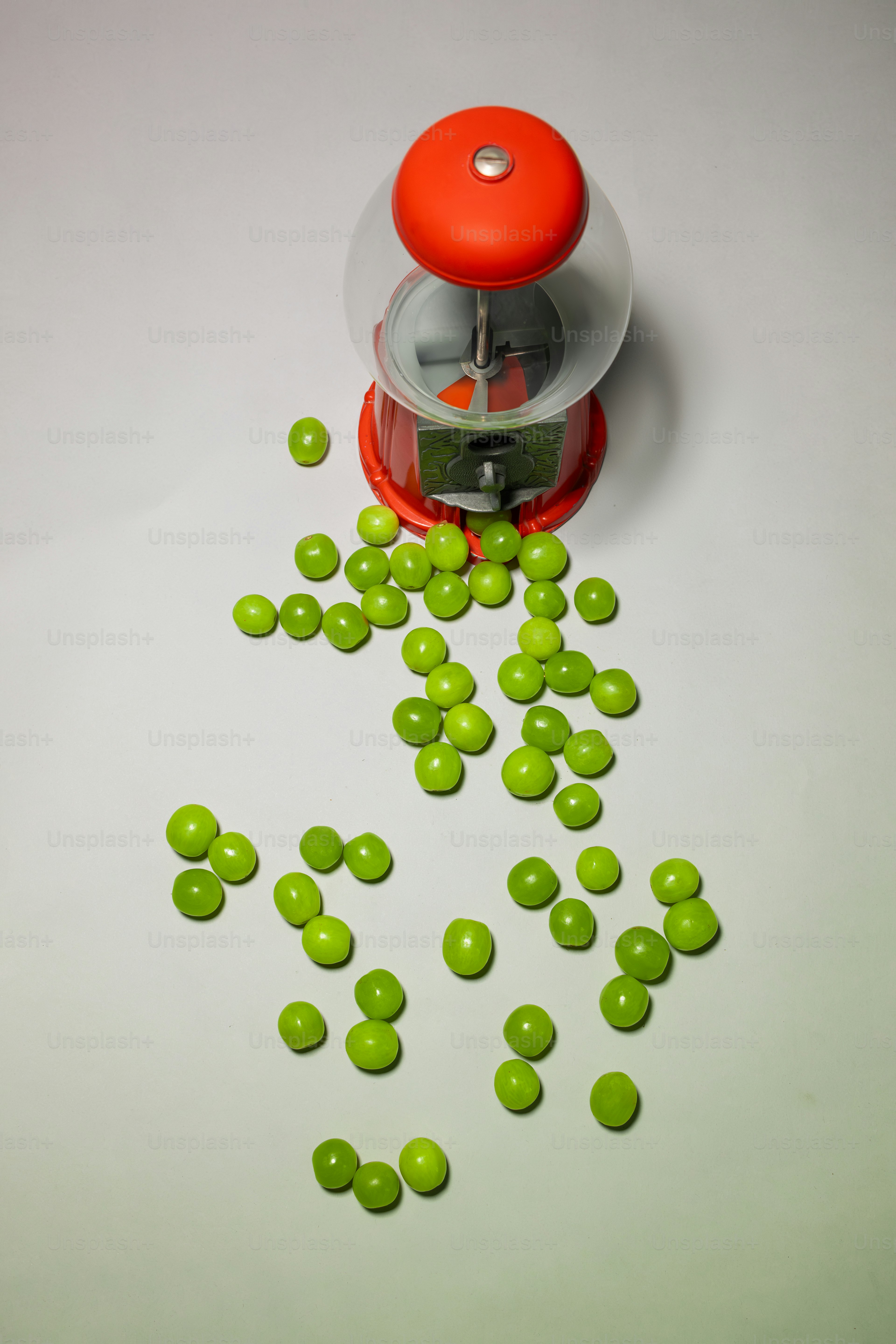 A red and green grinder filled with green candies