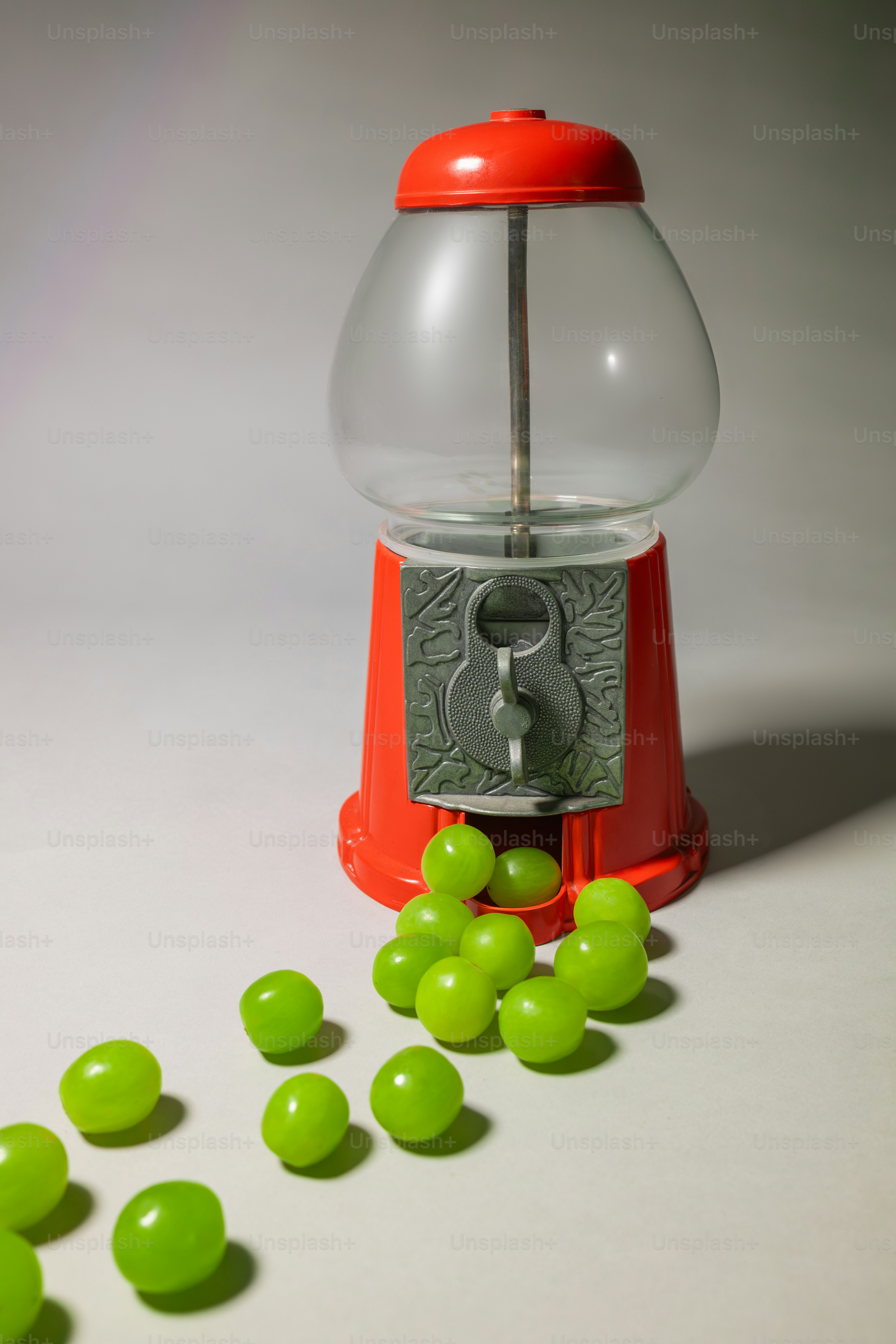 A gummy machine with a bunch of green candies in front of it