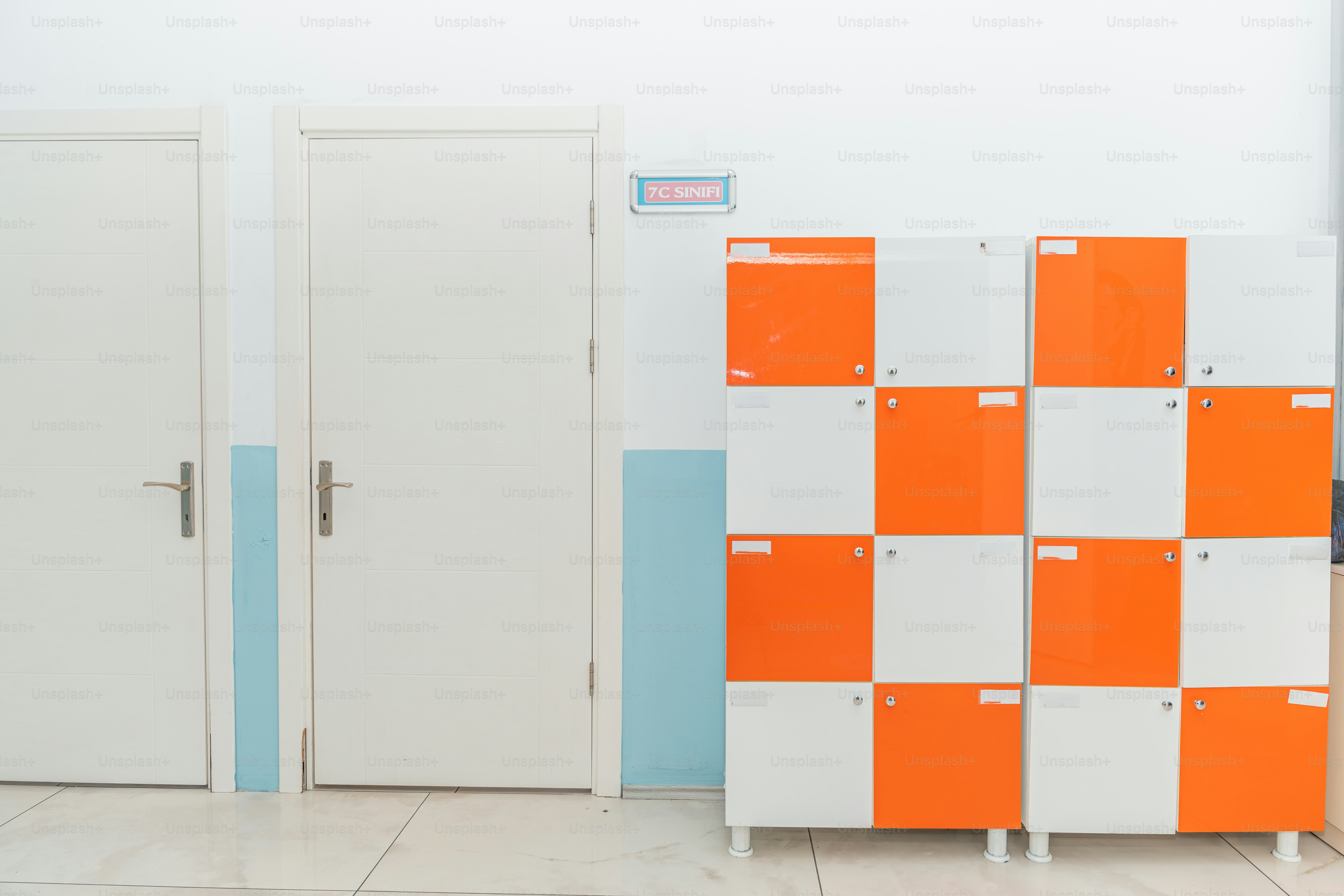 A group of orange and white lockers in a room