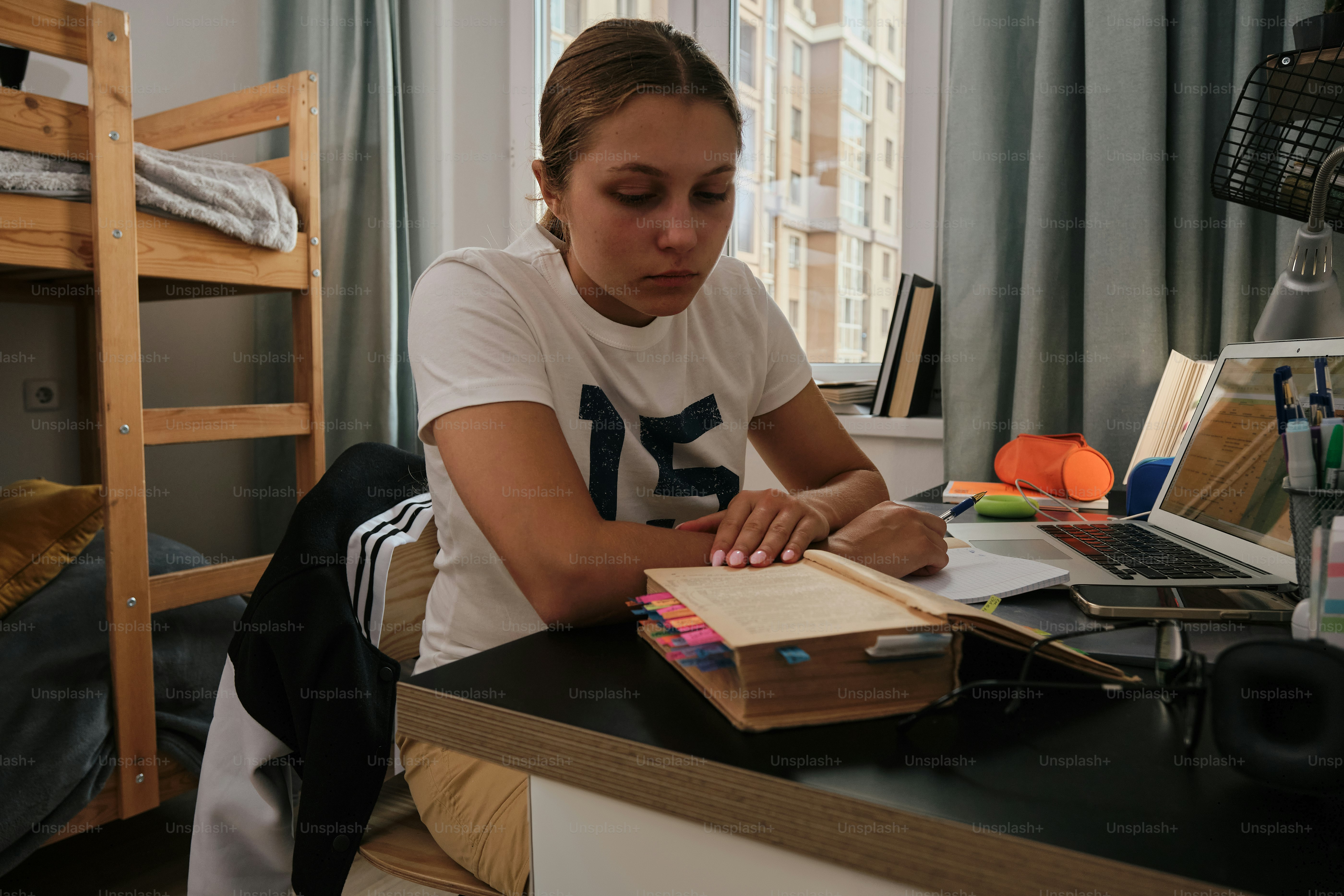A woman sitting at a desk with a book