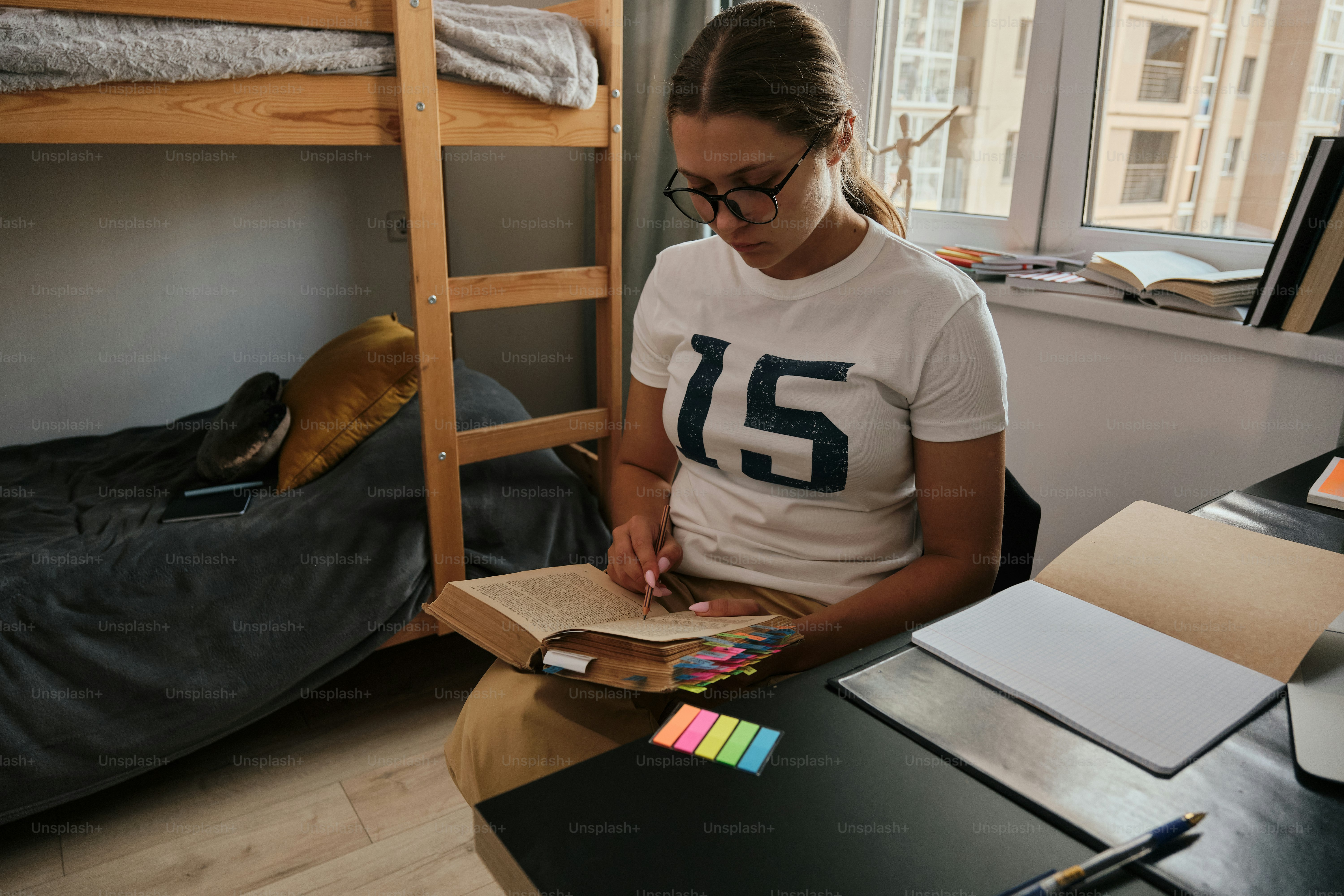 A woman sitting on a bed reading a book