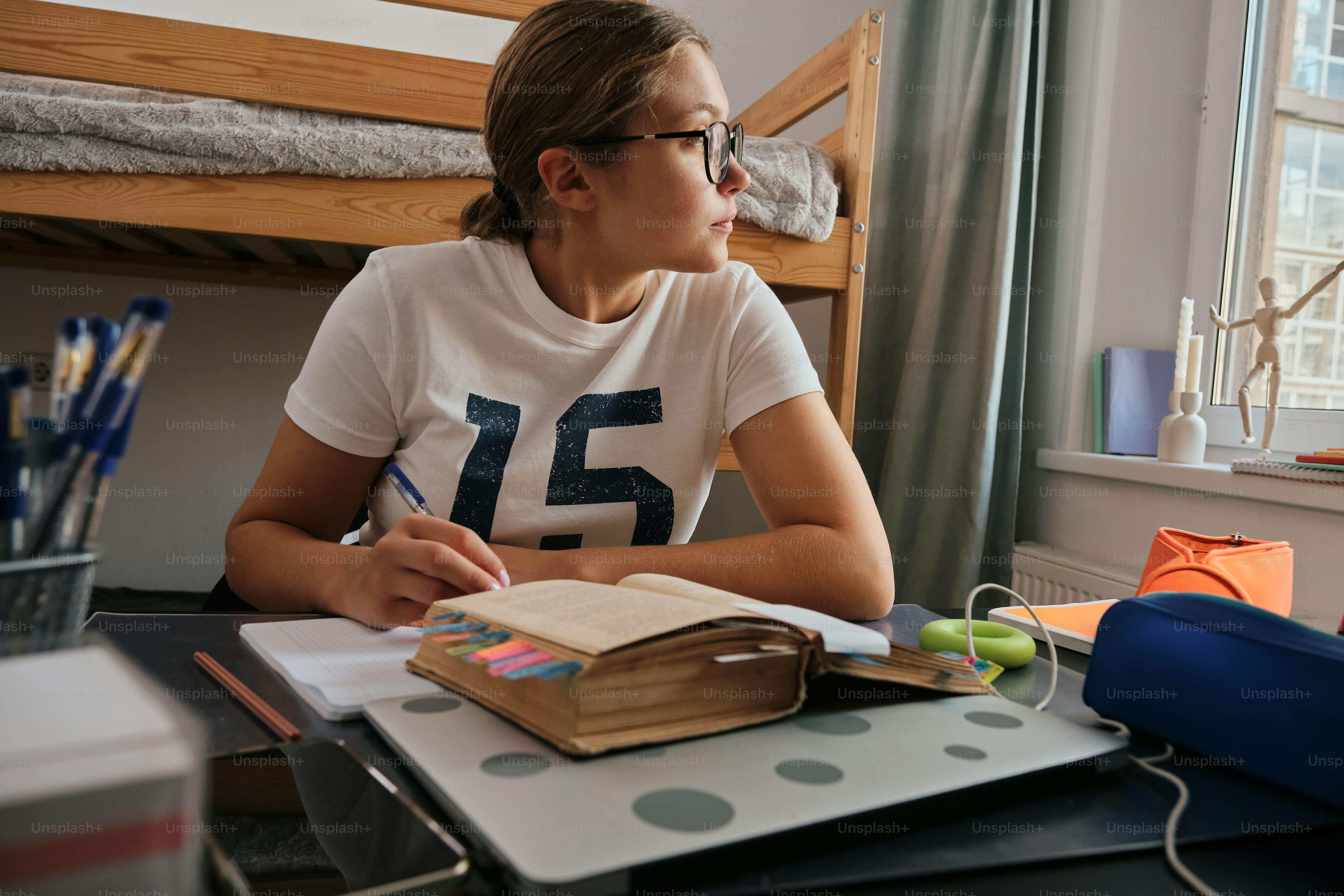 A woman sitting at a desk writing in a notebook