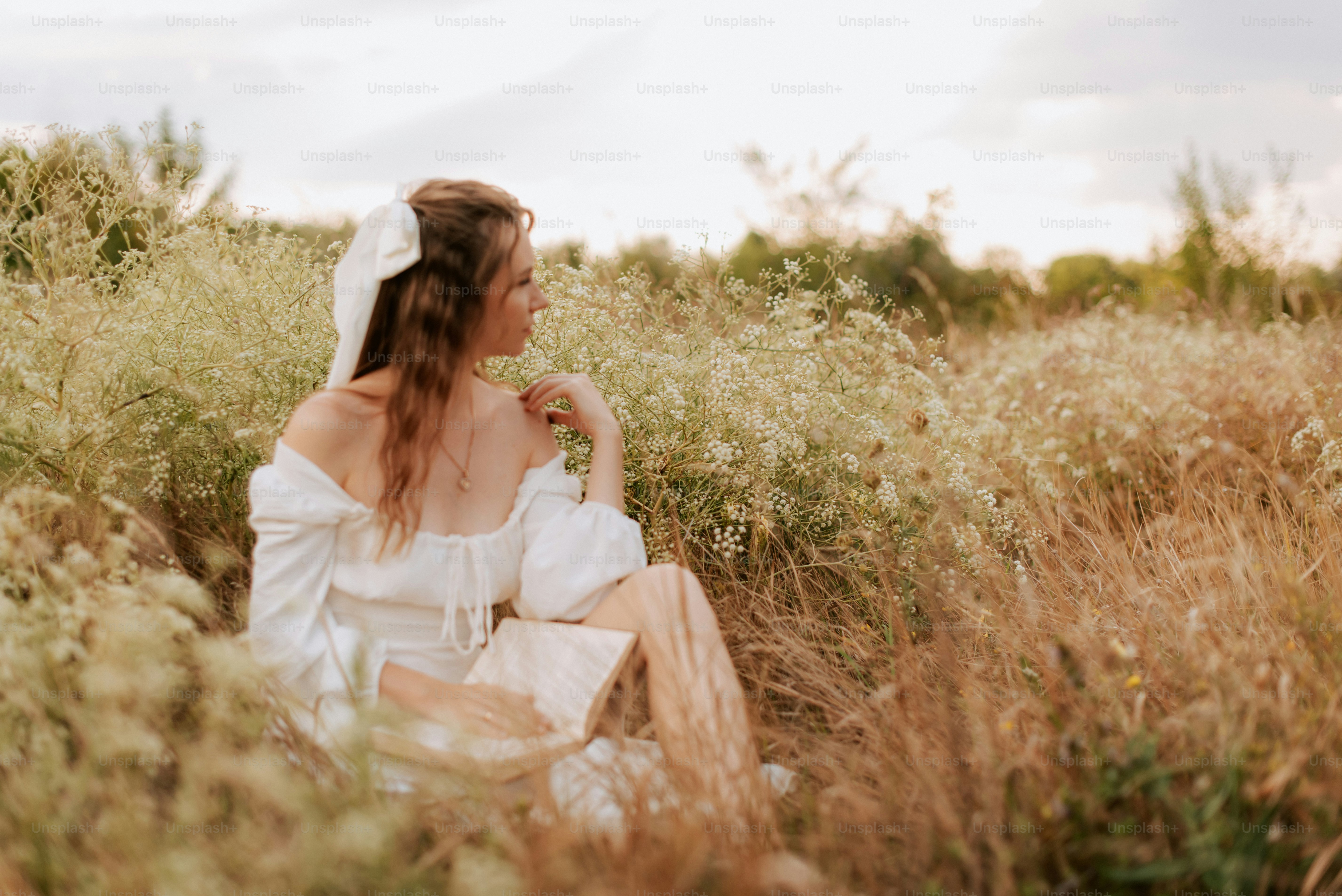A woman sitting in a field of tall grass photo – Summer Image on Unsplash