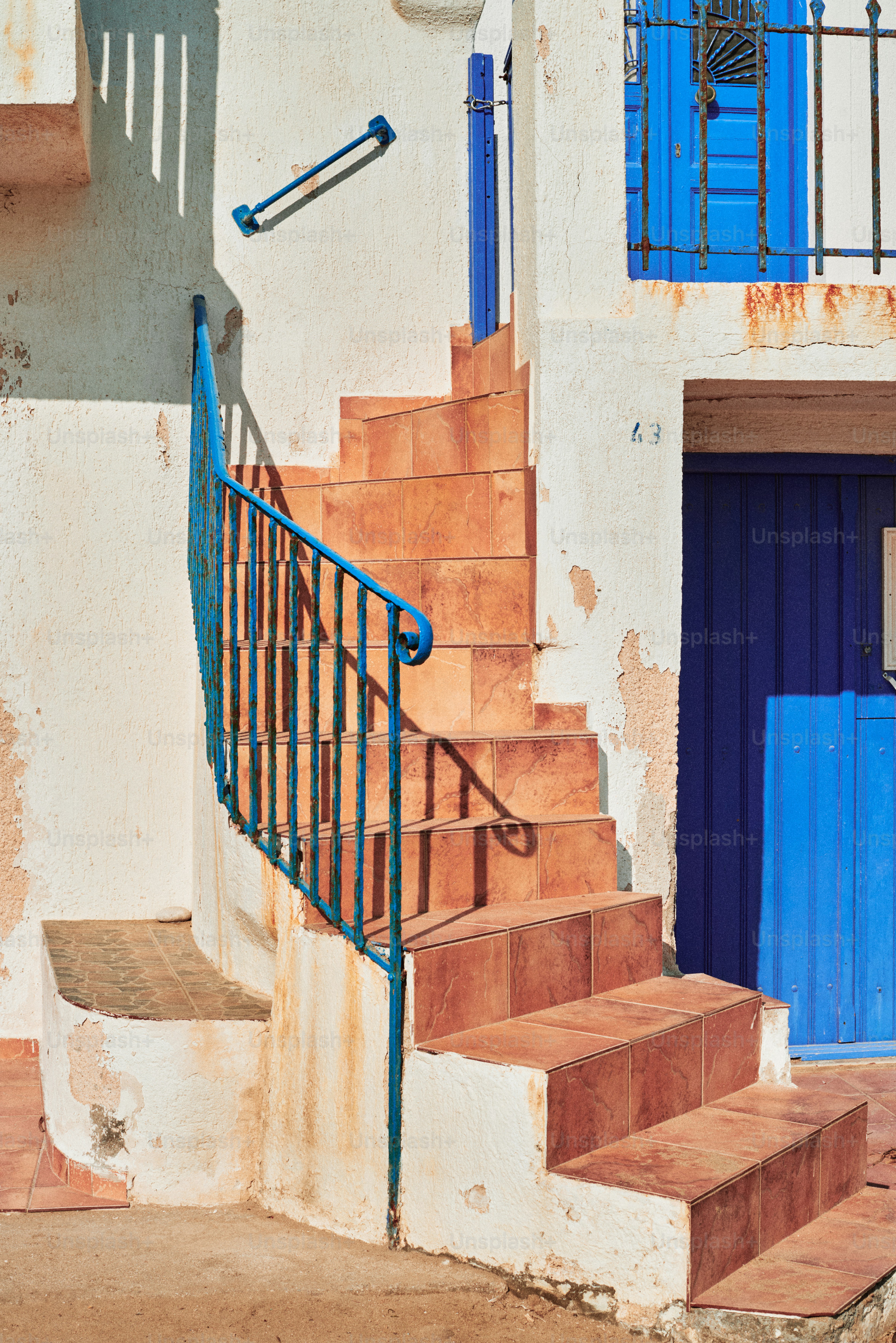 A set of stairs leading up to a blue door