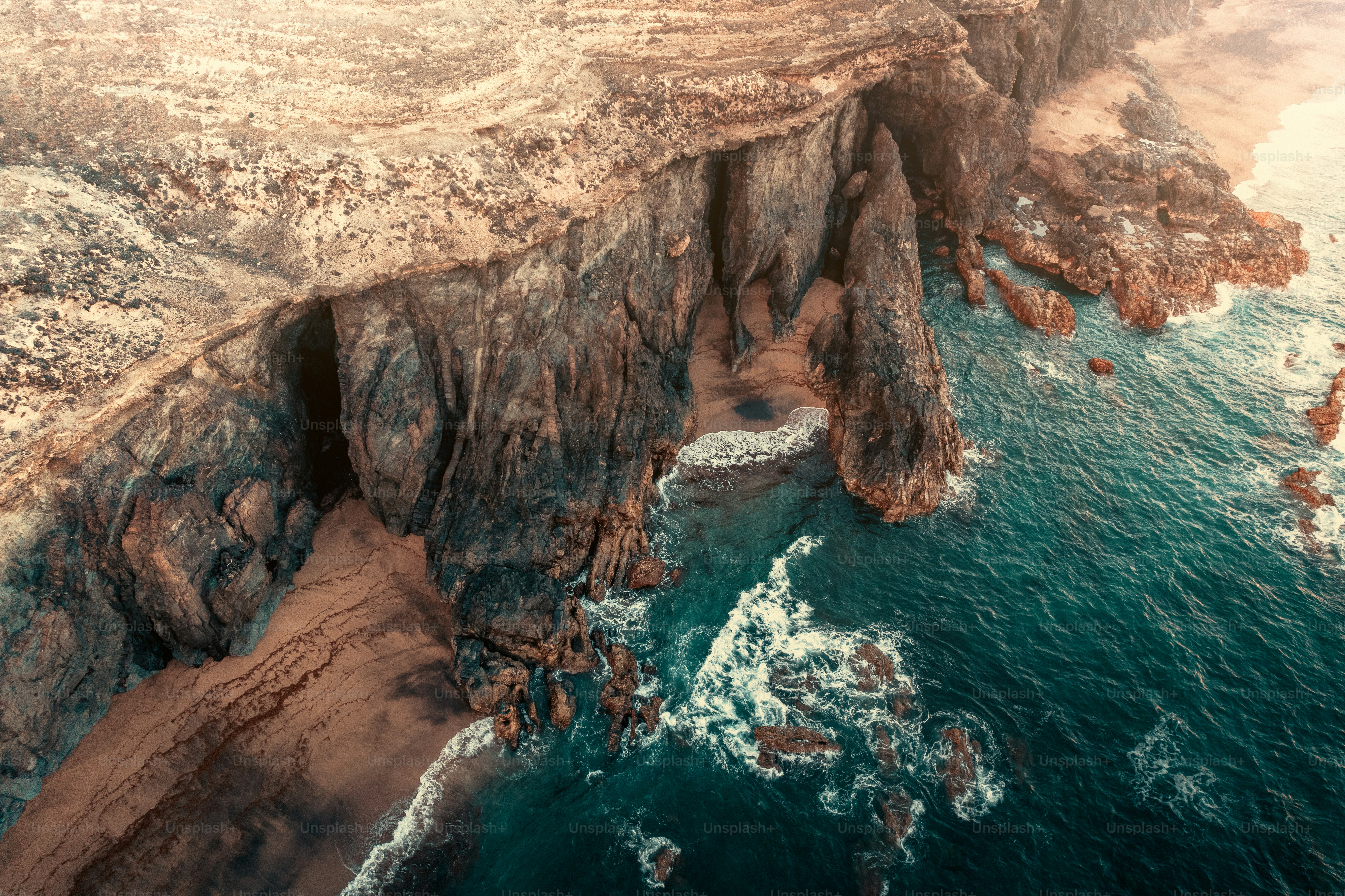 An aerial view of a rocky coastline with a body of water