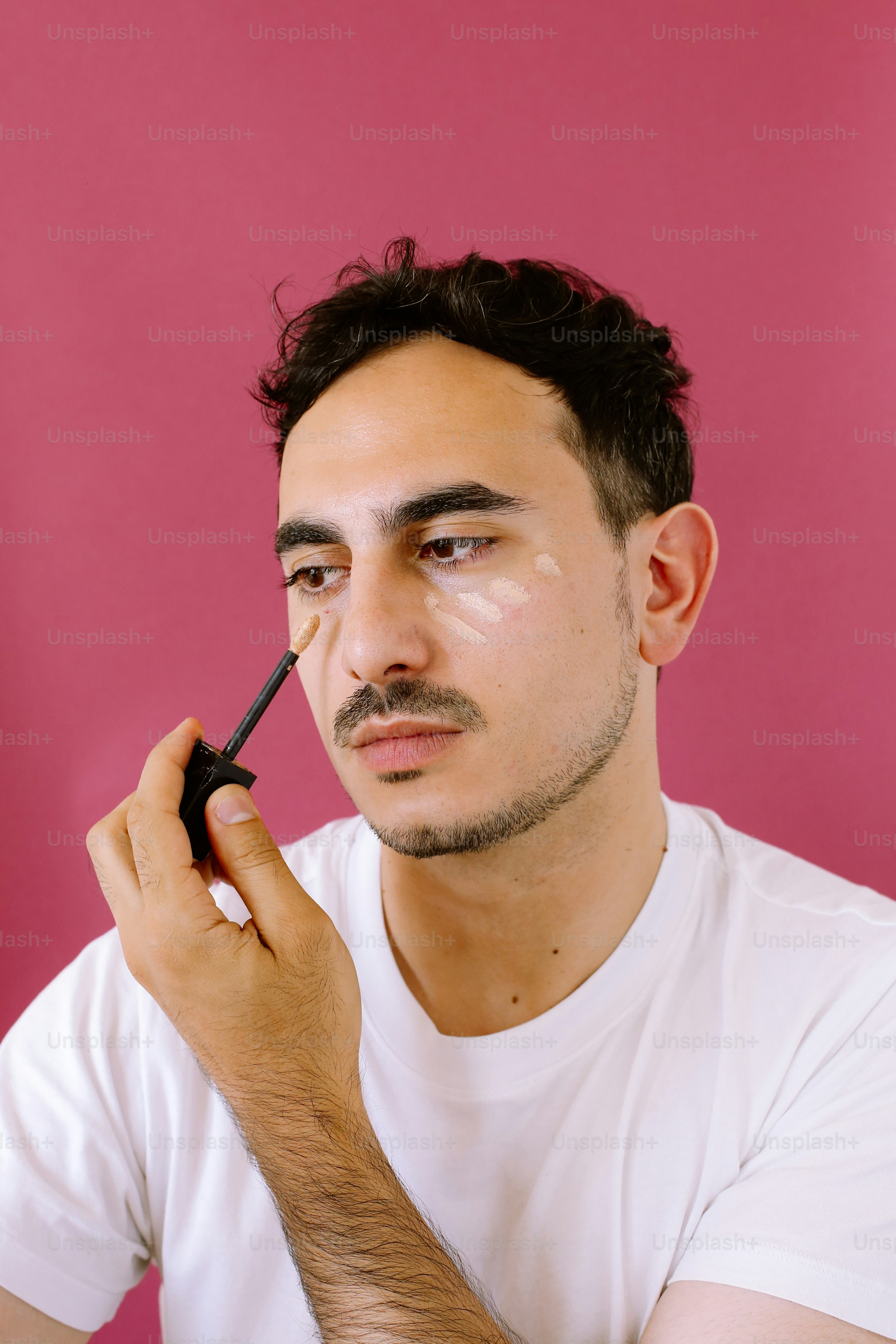 Ein Mann macht etwas mit seinem Eyeliner-Pinsel