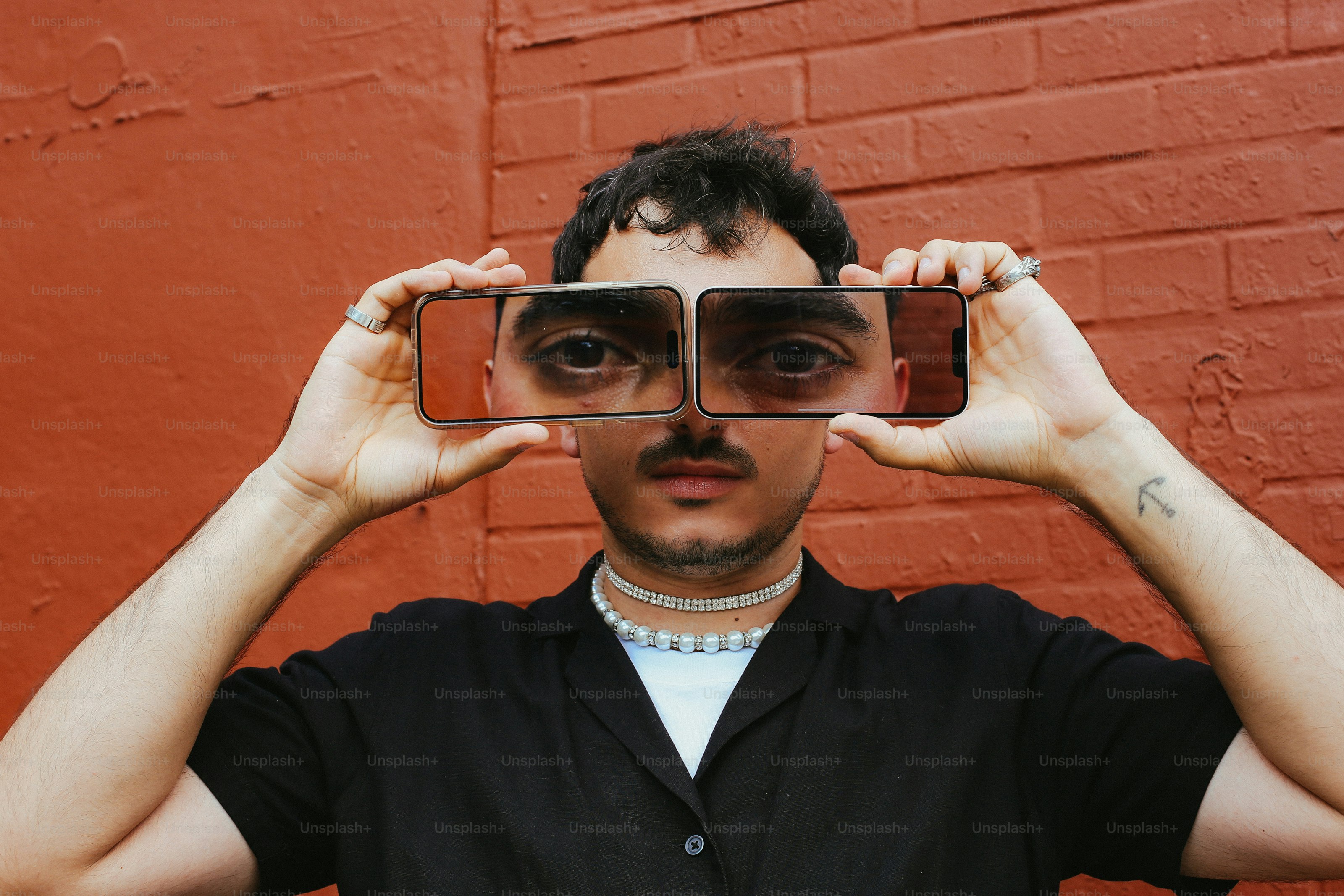 A man holding up a pair of glasses to his face