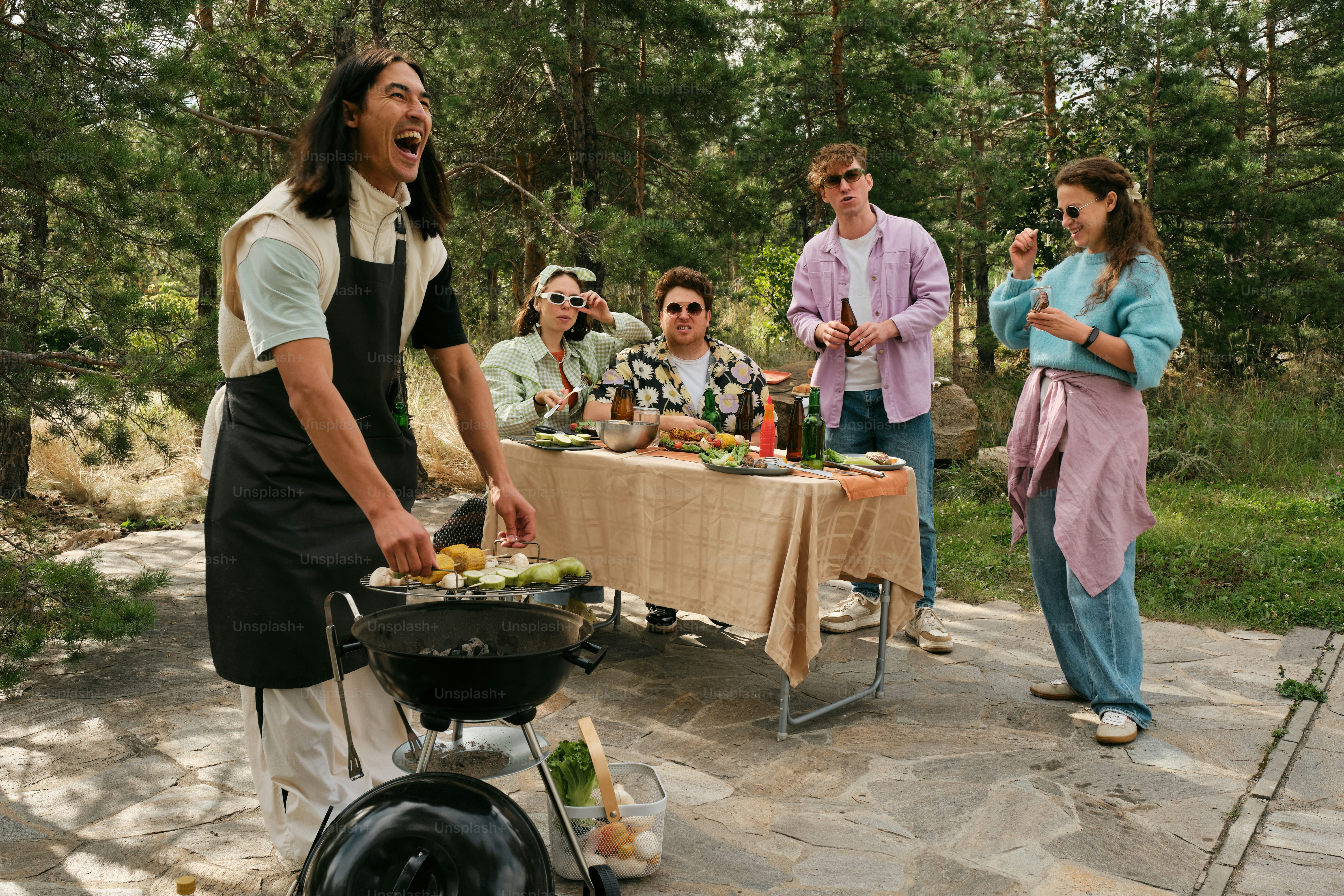 A group of people standing around a table with food on it