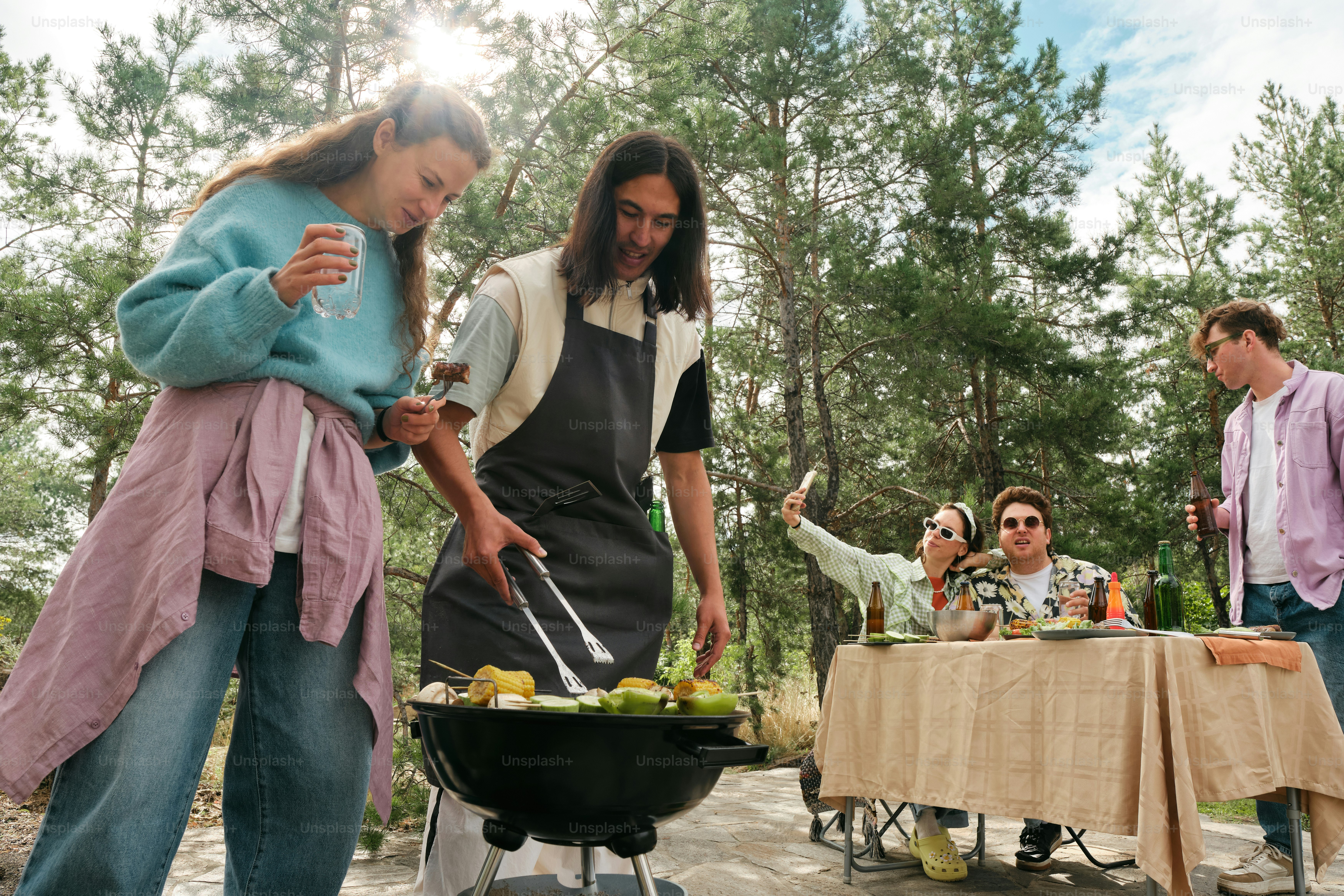 A group of people standing around a table with food on it