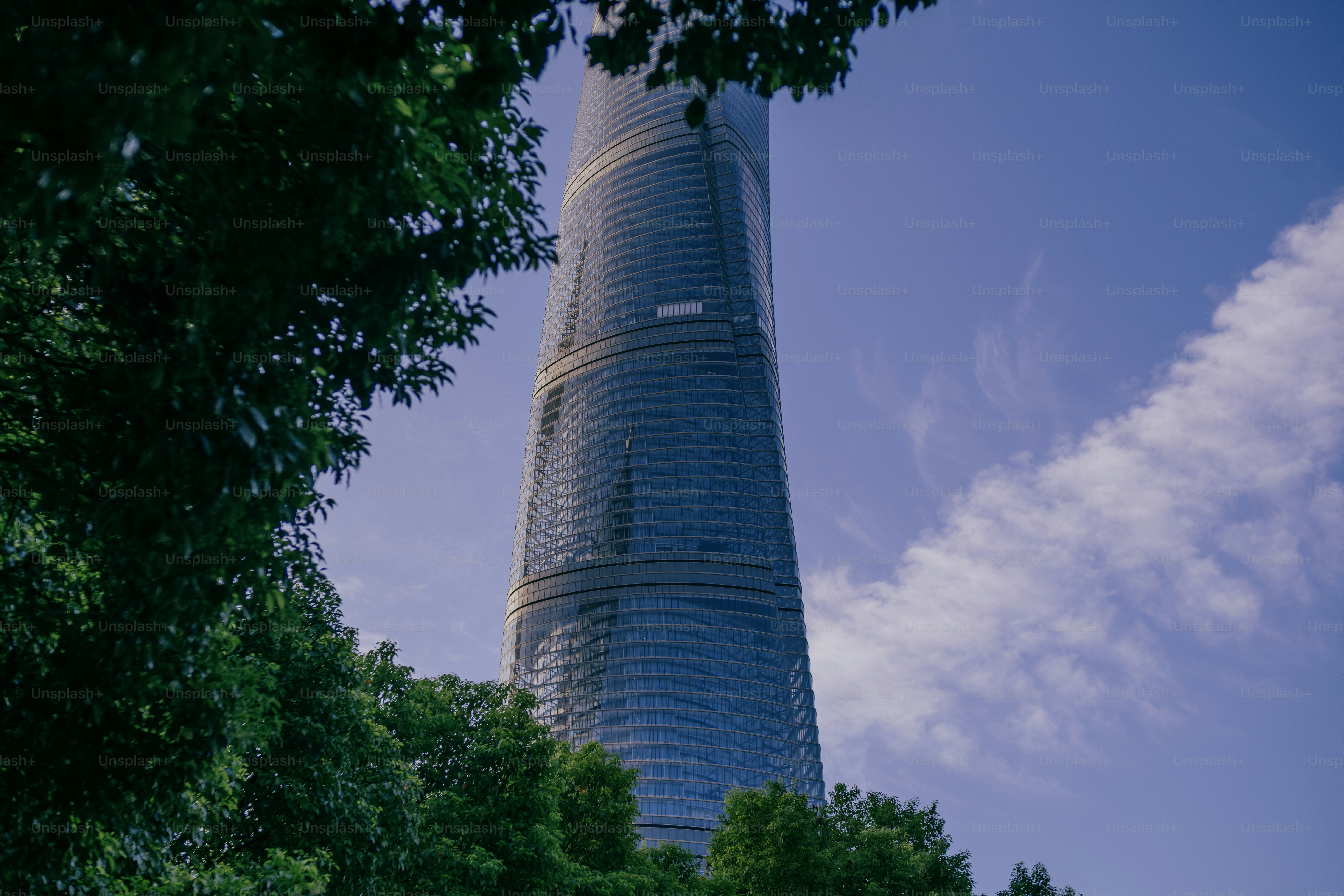 Un edificio molto alto con molti alberi di fronte