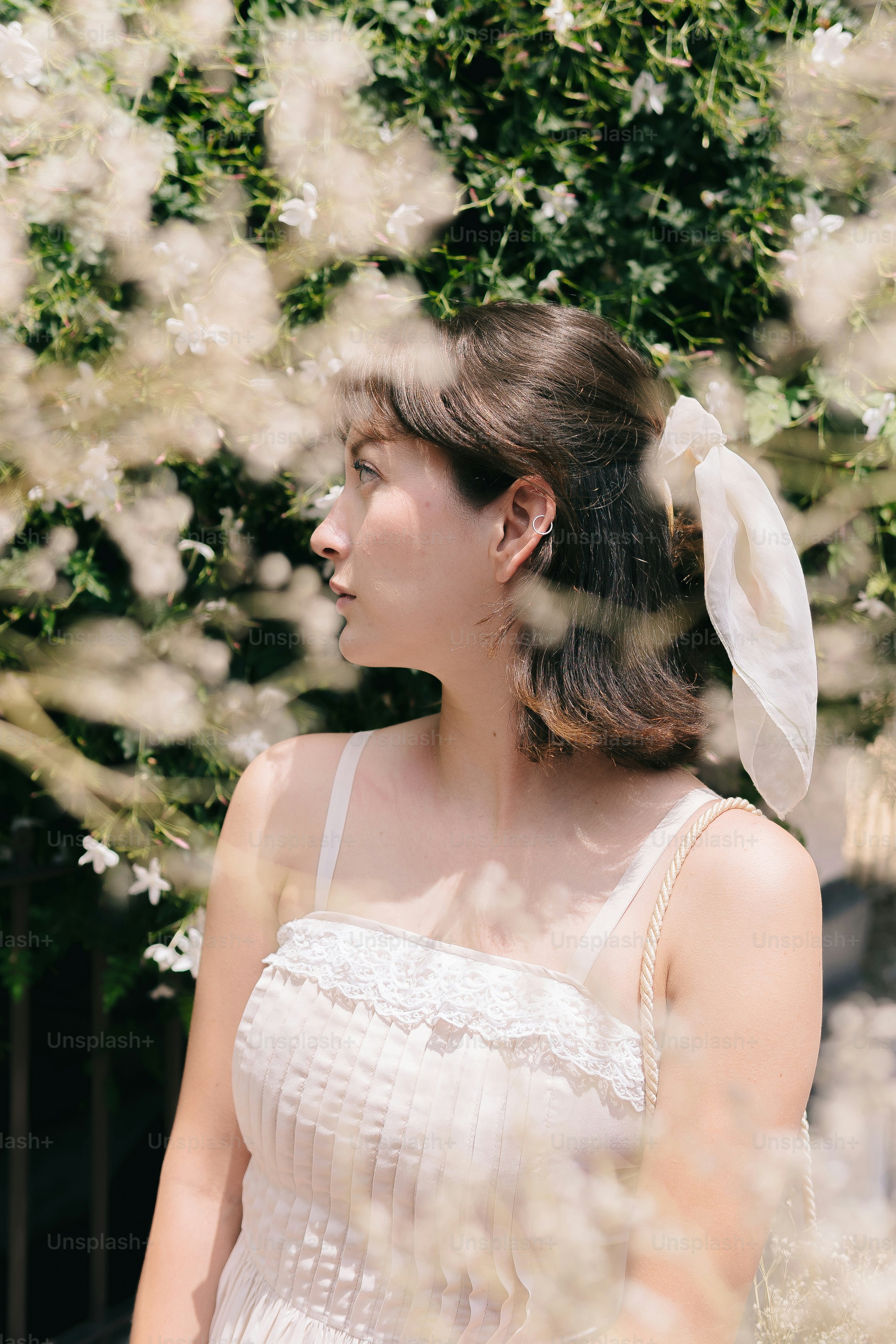 A woman in a white dress standing in front of a tree photo – Woman ...