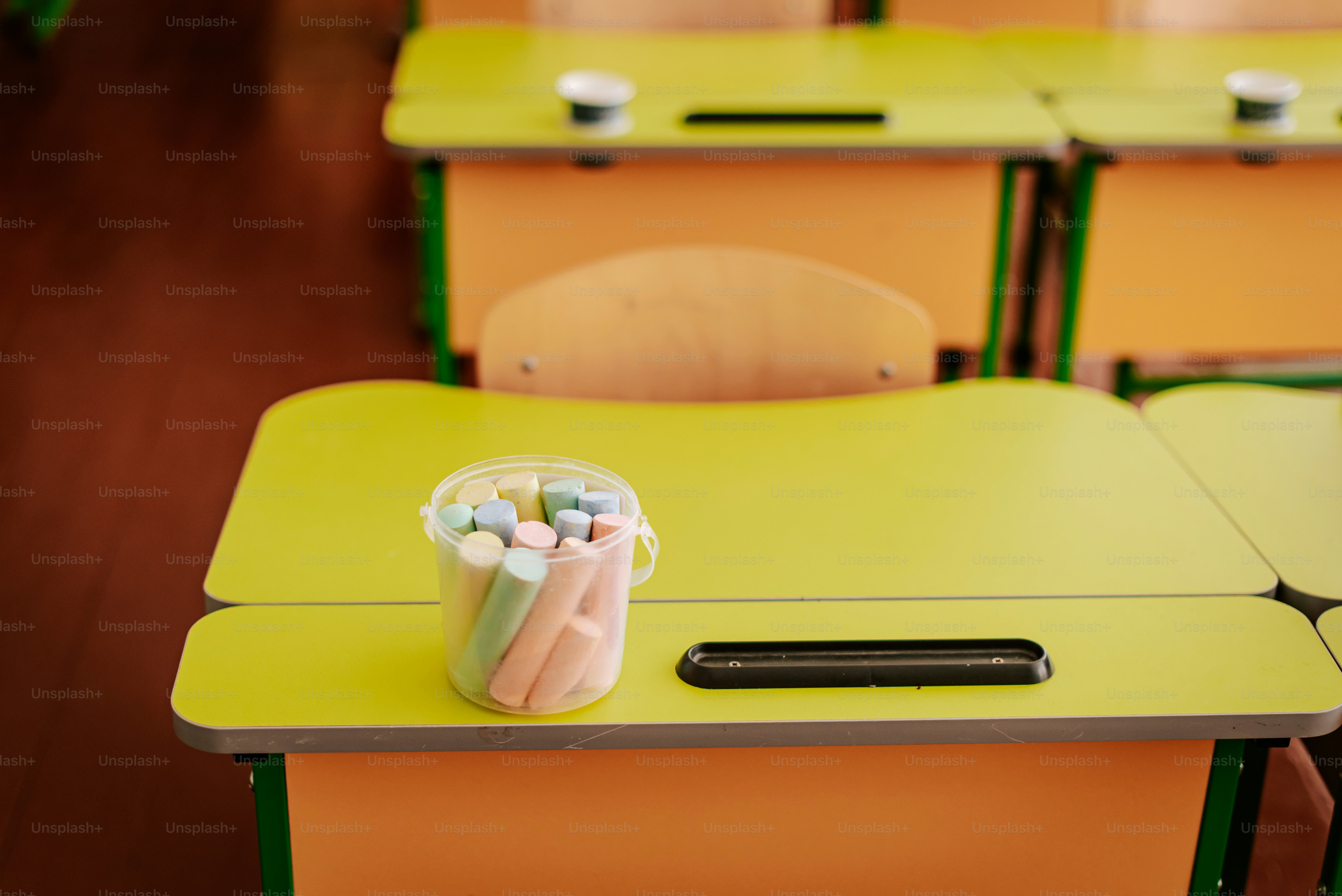 A row of desks with a cell phone on top of them