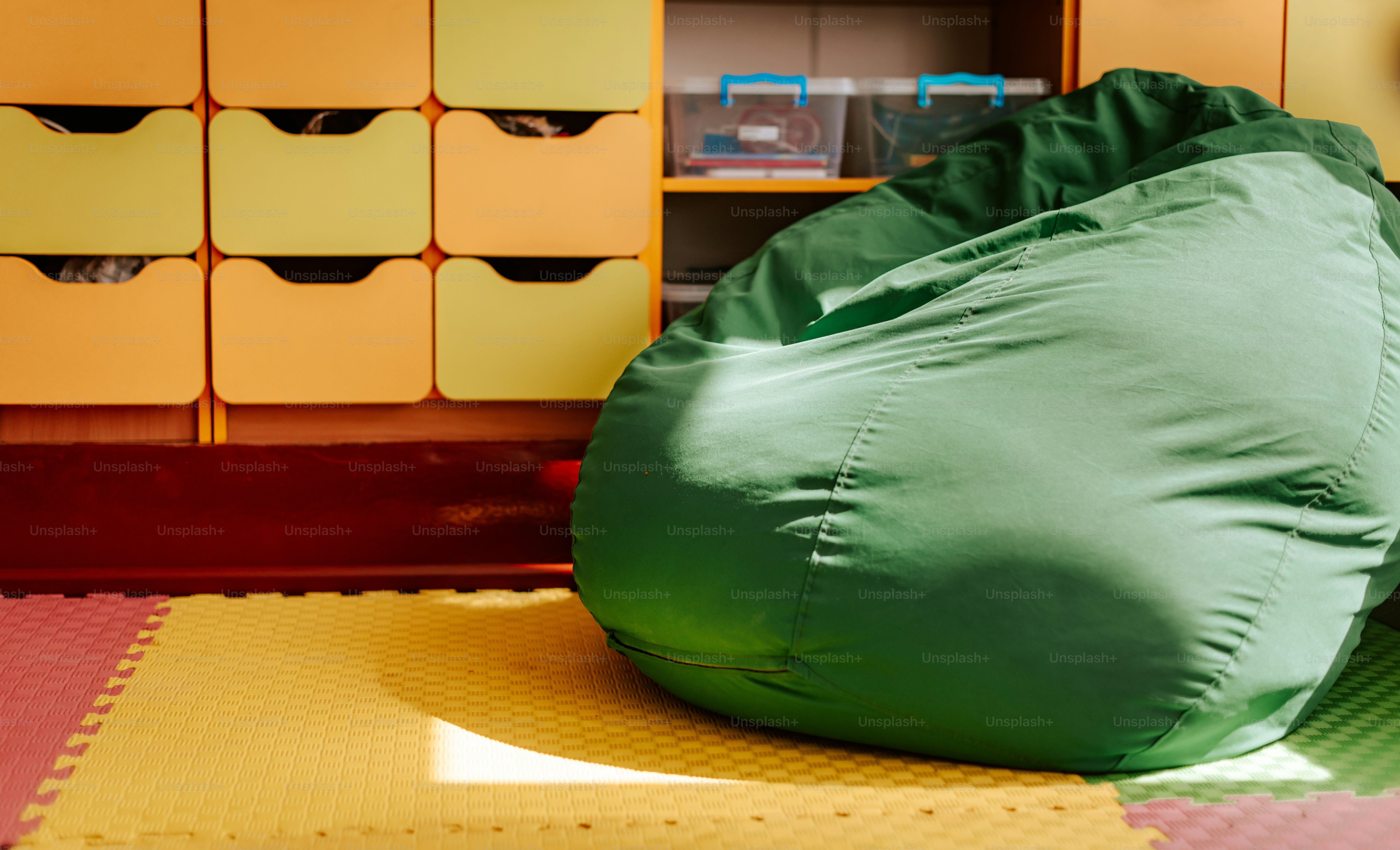A green bean bag sitting on top of a floor