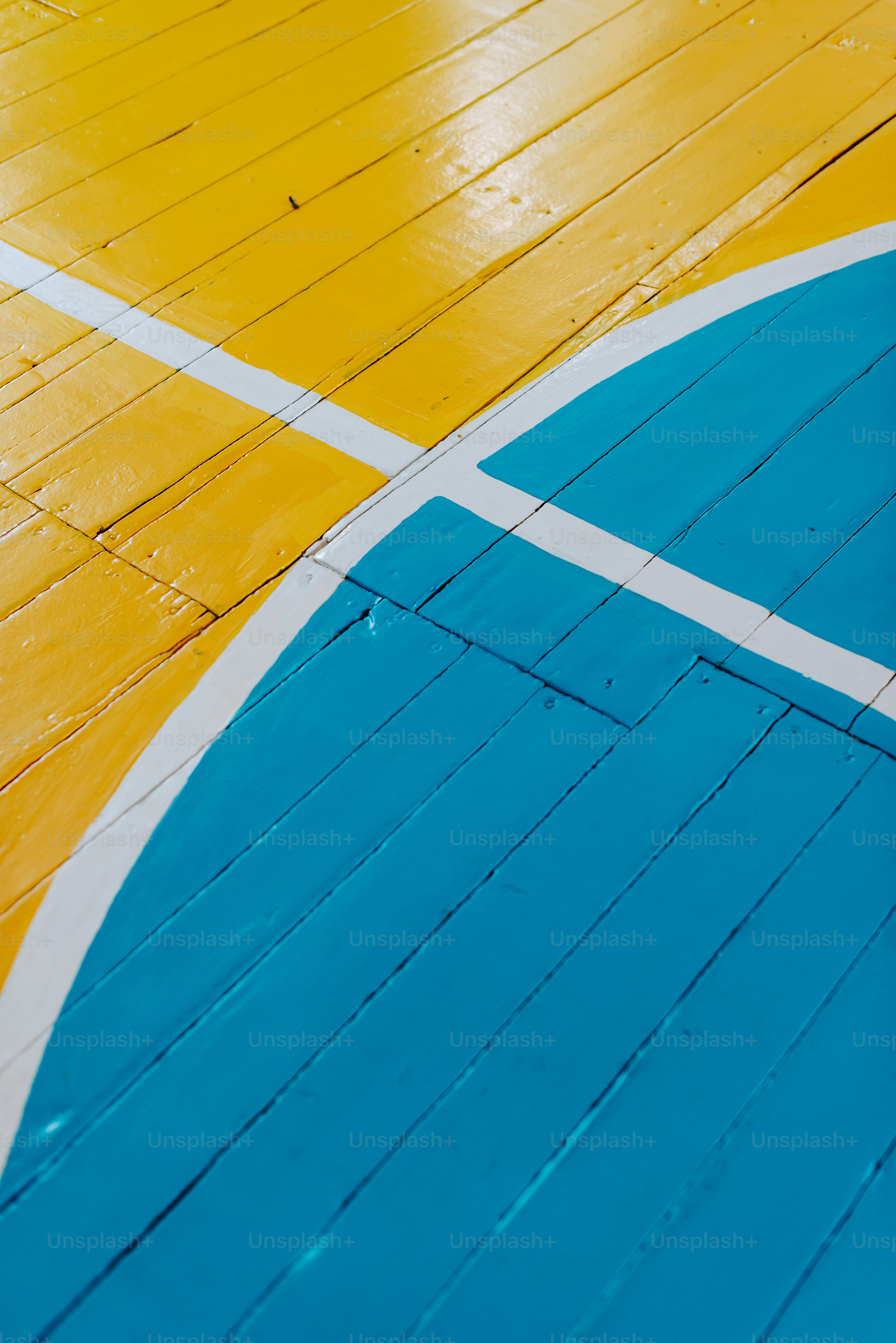 A blue and yellow basketball court with a white line