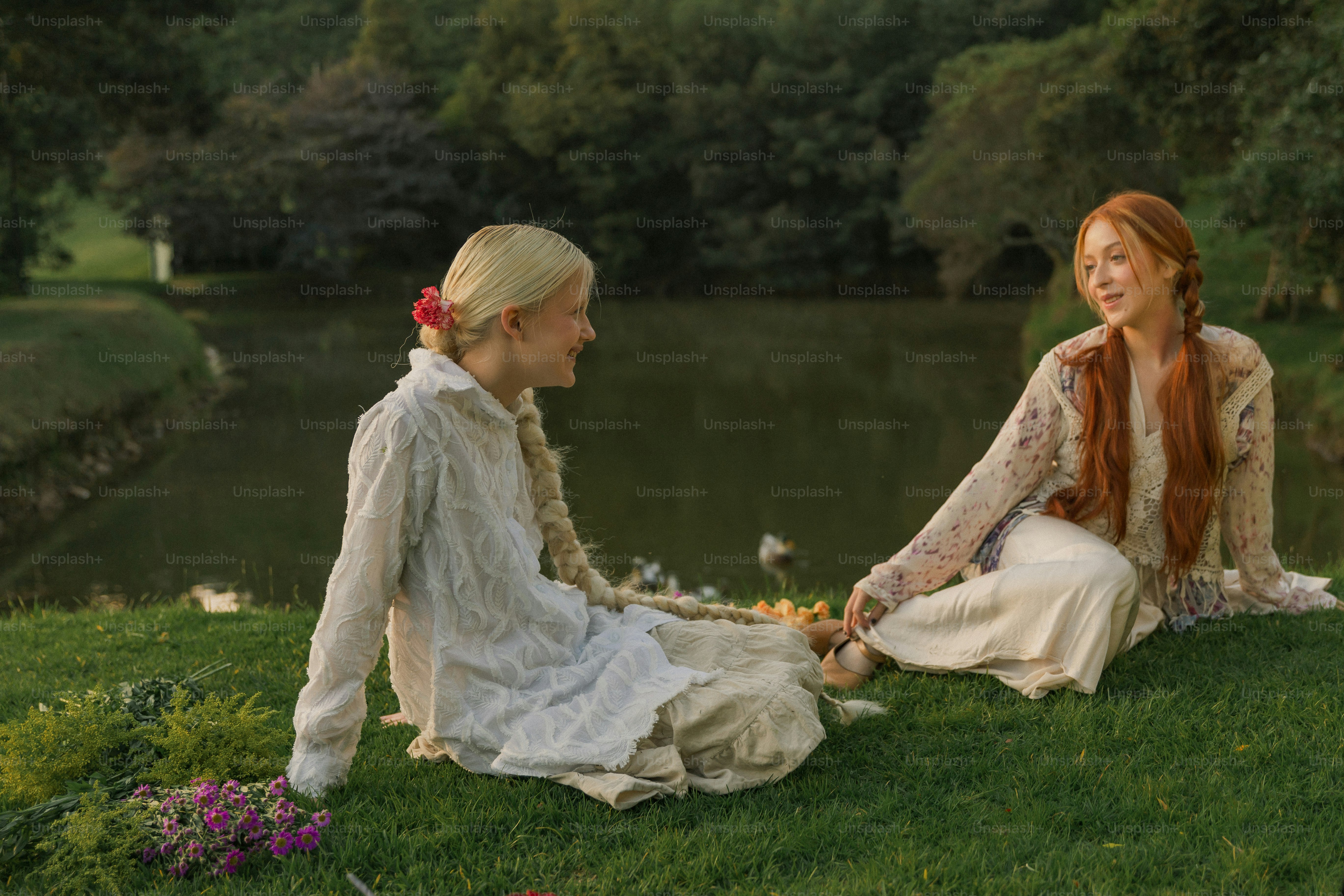 緑豊かな野原の上に座っている女性カップル