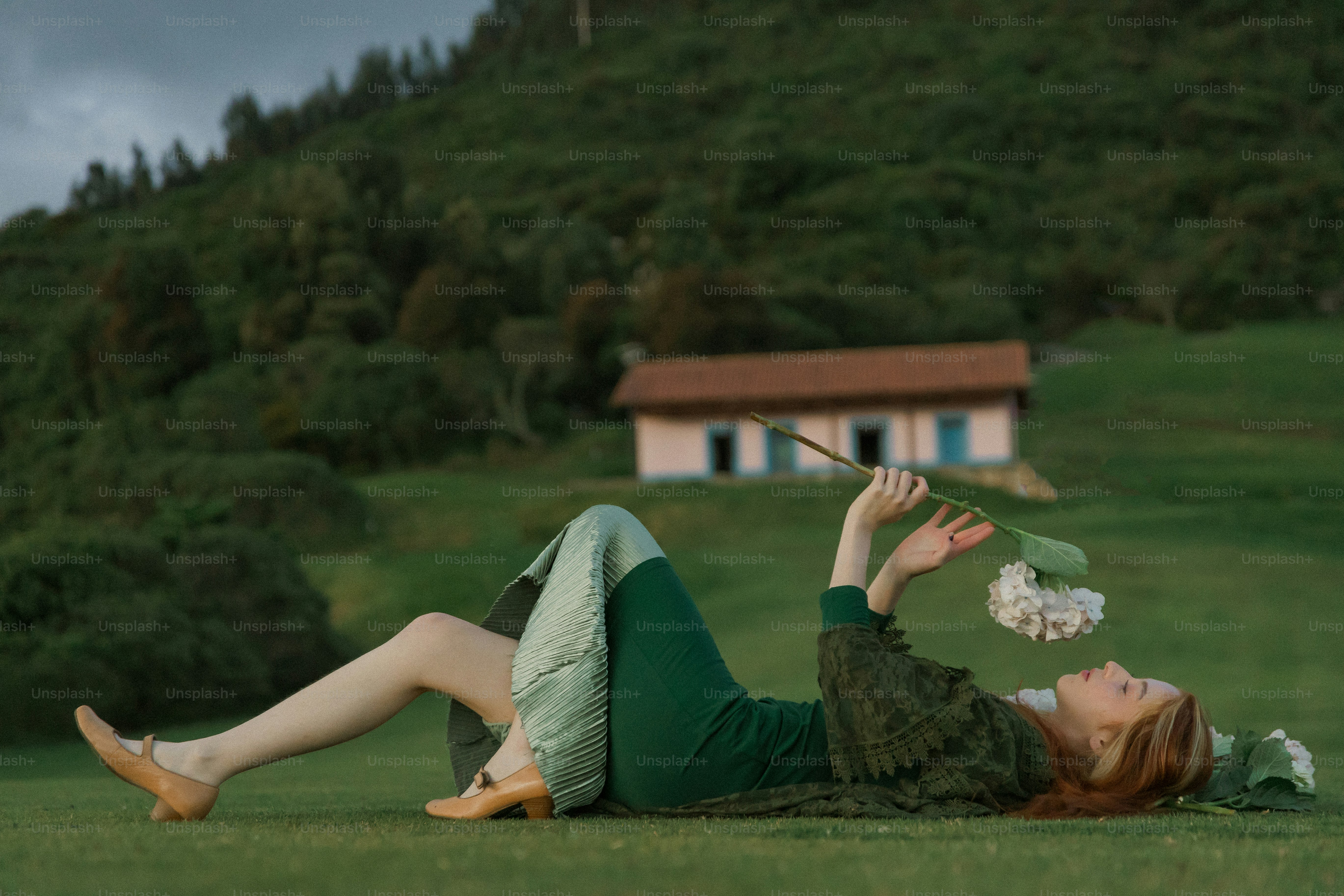 鳥を手に地面に横たわる女性