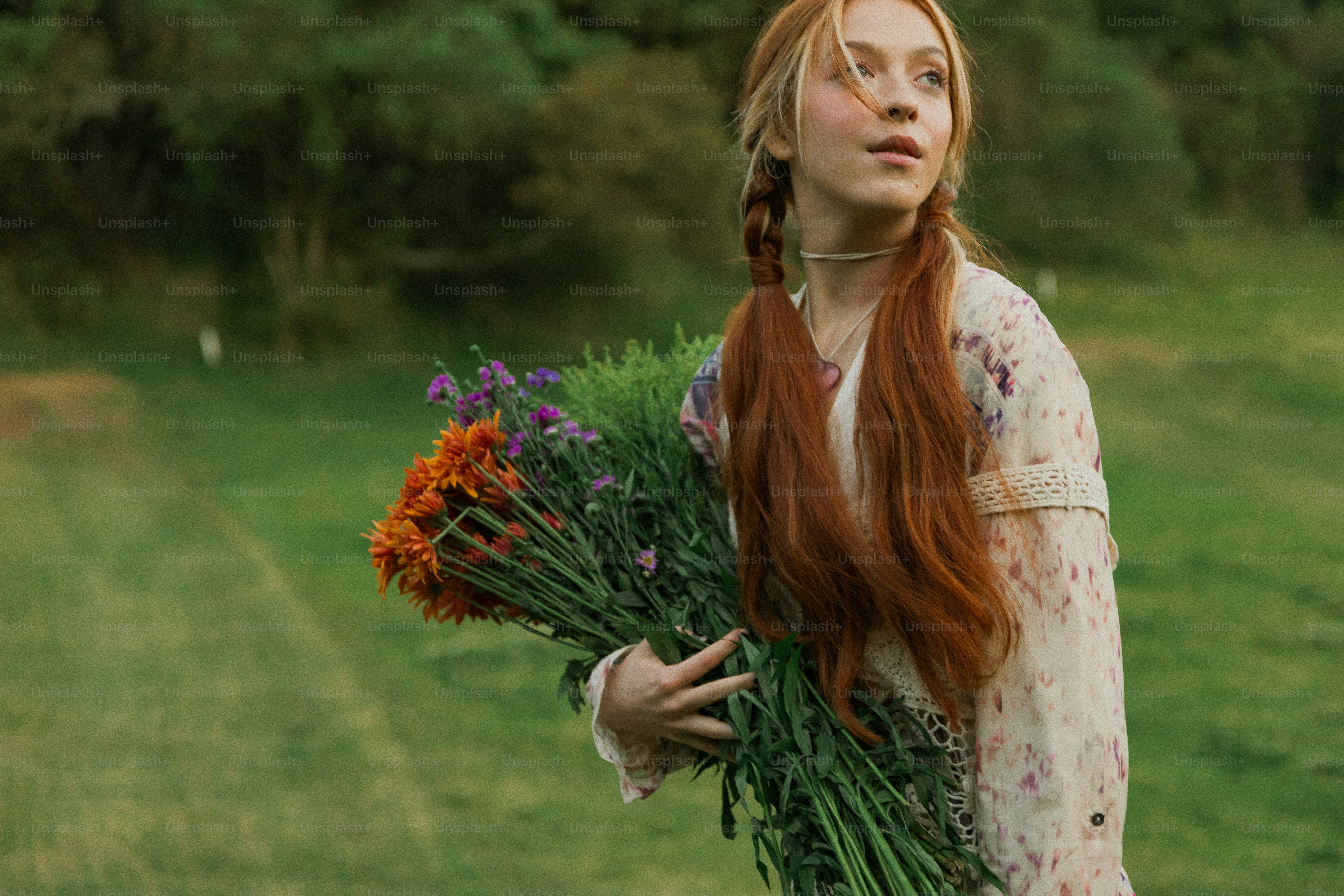 A woman with long red hair holding a bunch of flowers
