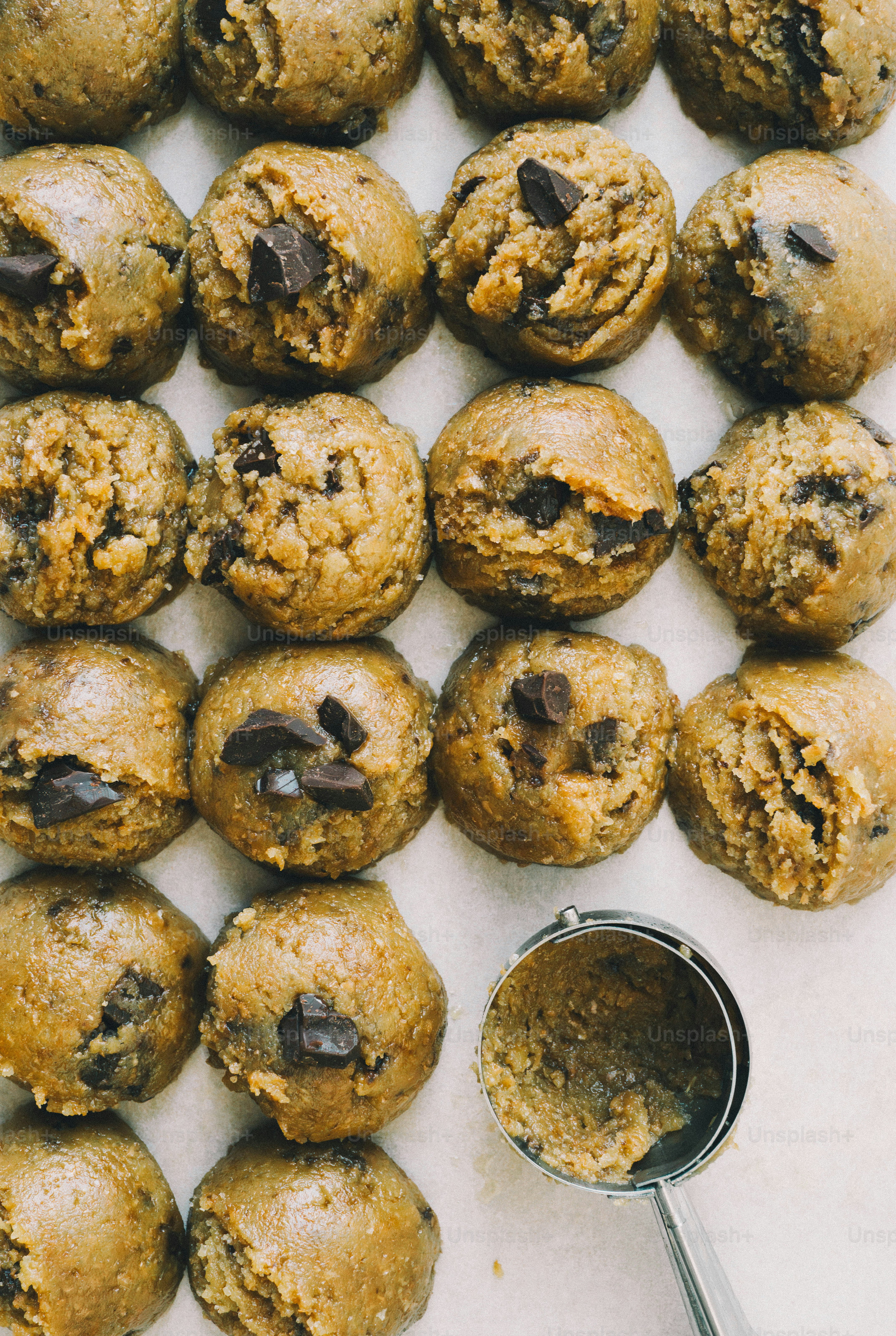 Un plateau de biscuits aux pépites de chocolat à côté d’une cuillère à biscuits