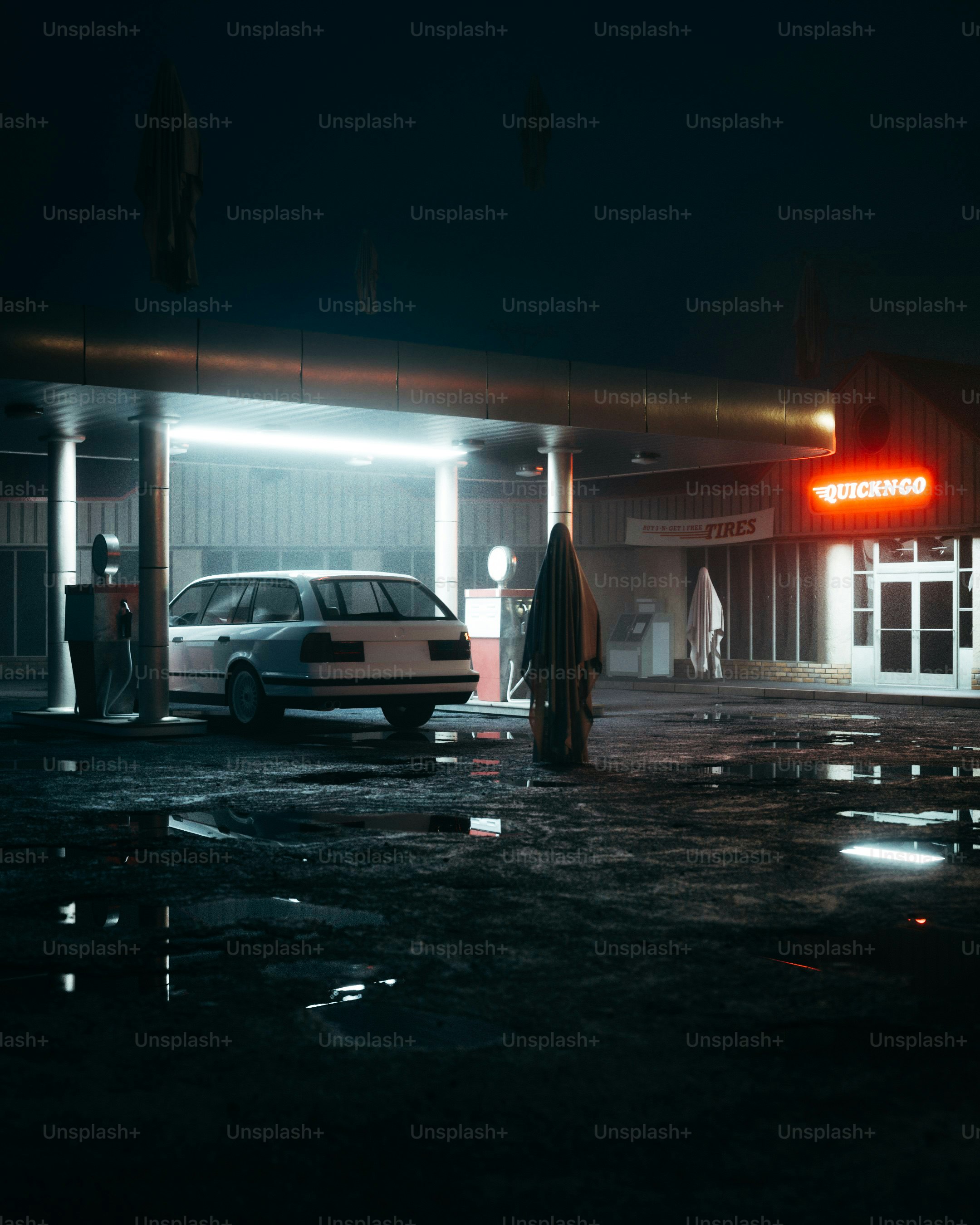 A car parked in front of a gas station at night