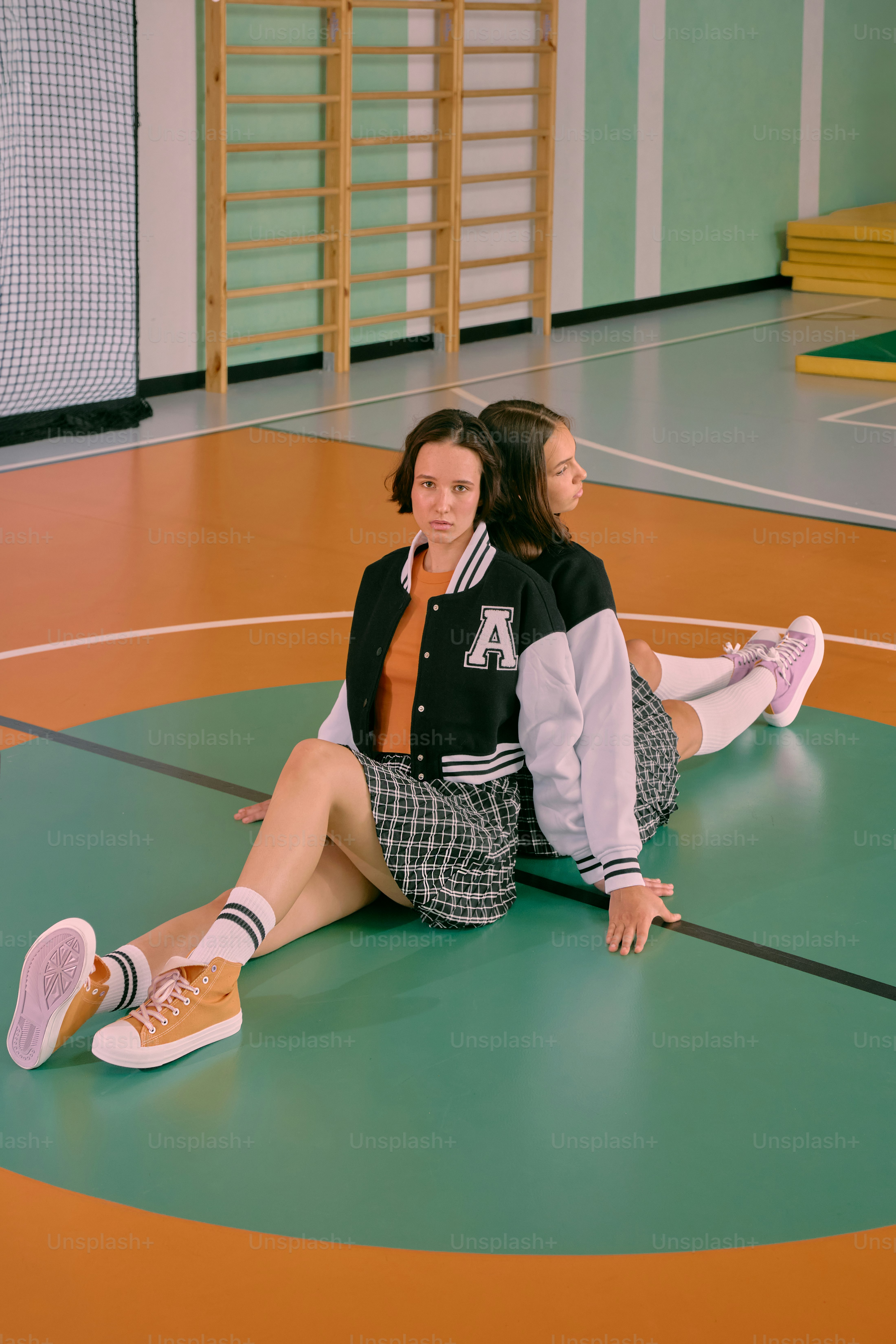 Dos mujeres sentadas en el suelo de un gimnasio