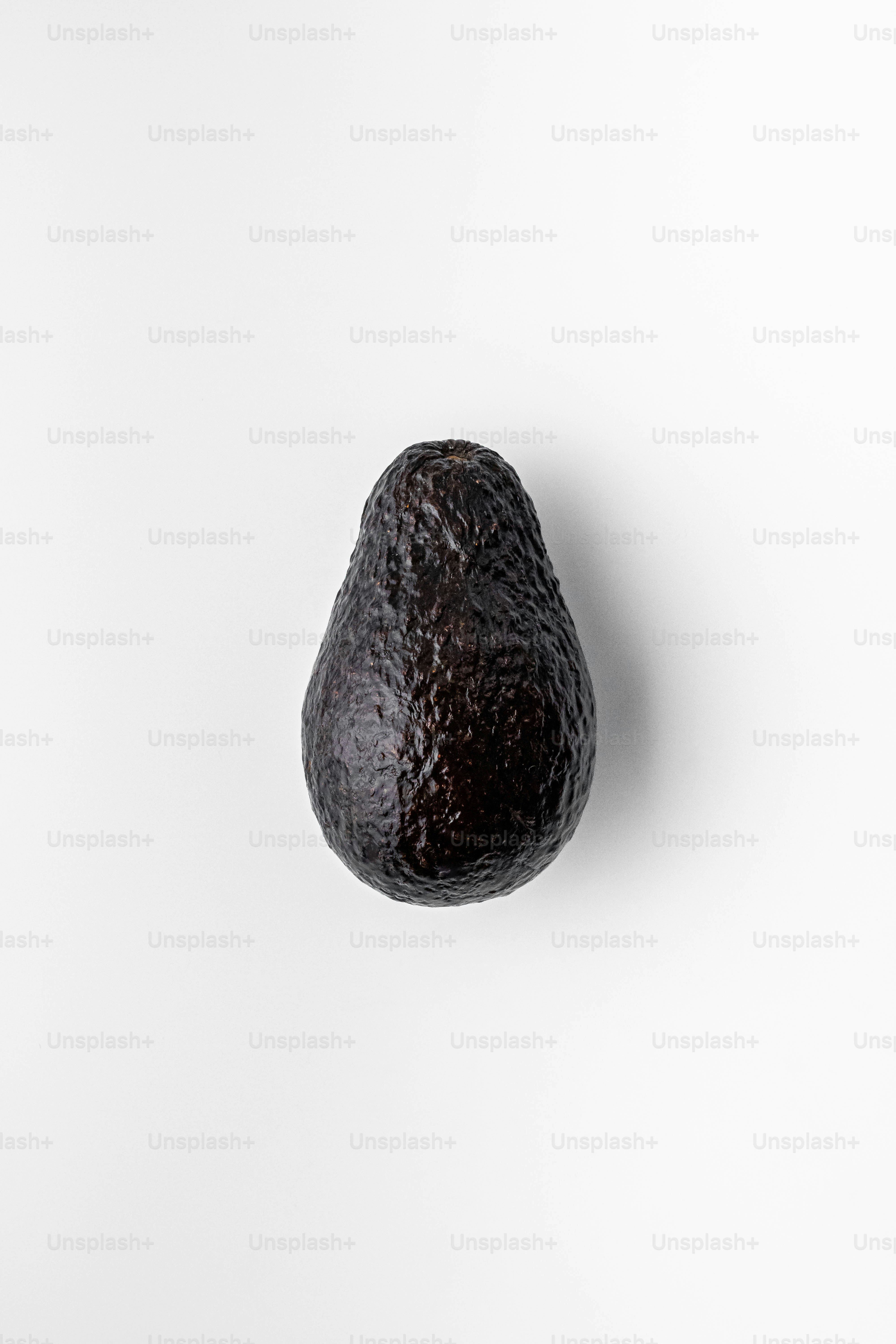 An avocado hanging on a white wall