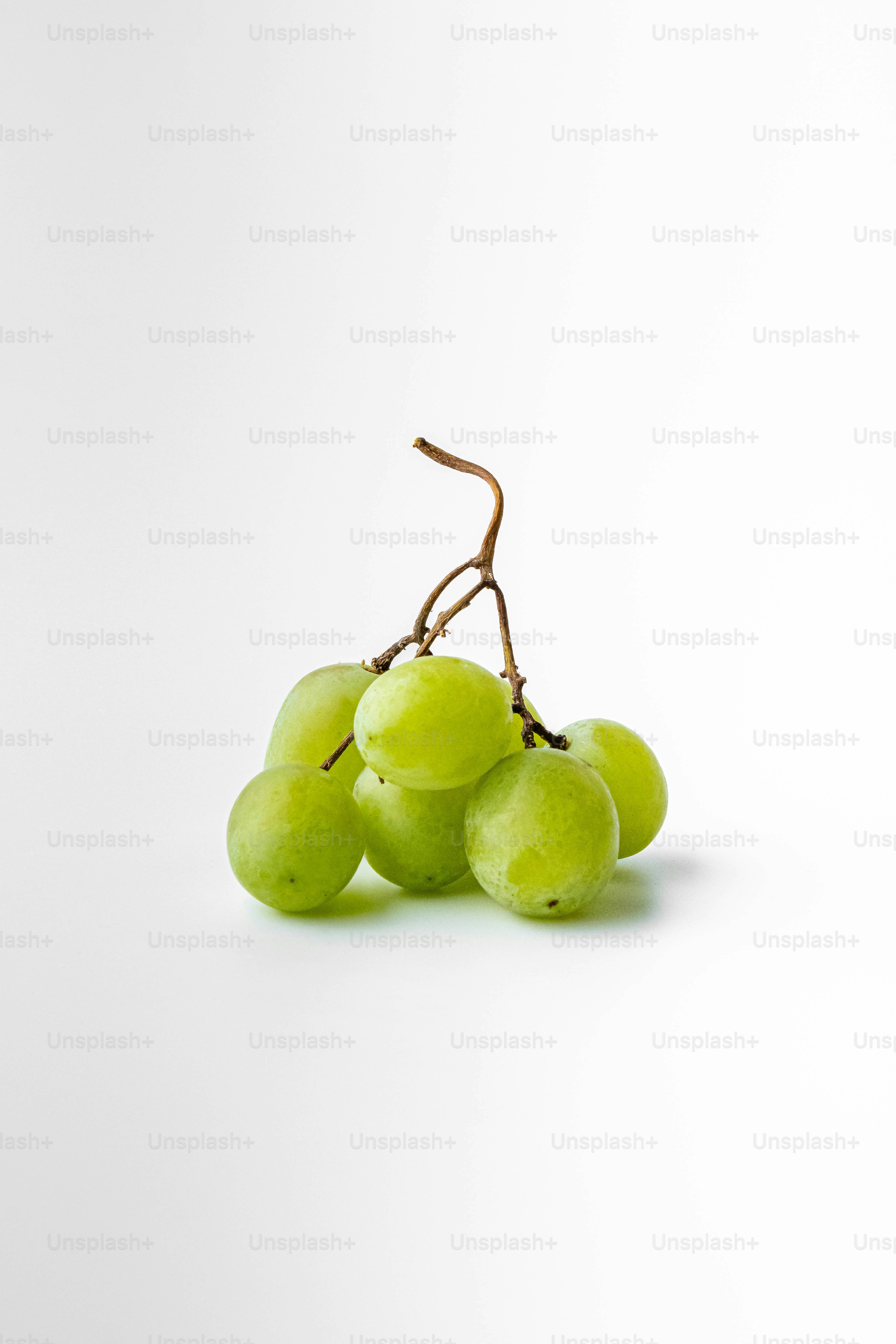 Eine Traube grüner Trauben sitzt auf einem weißen Tisch