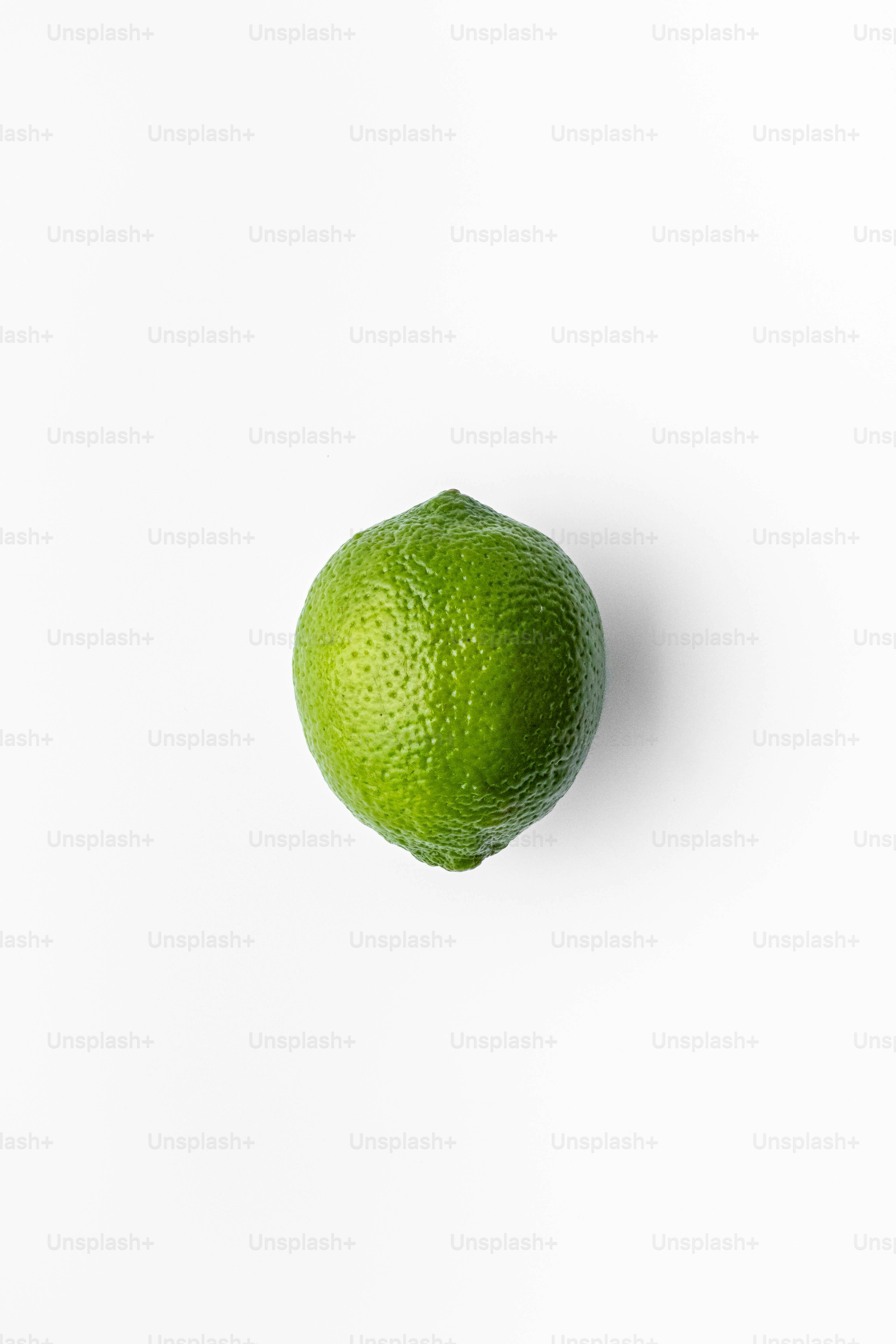 A lime is sitting on a white surface