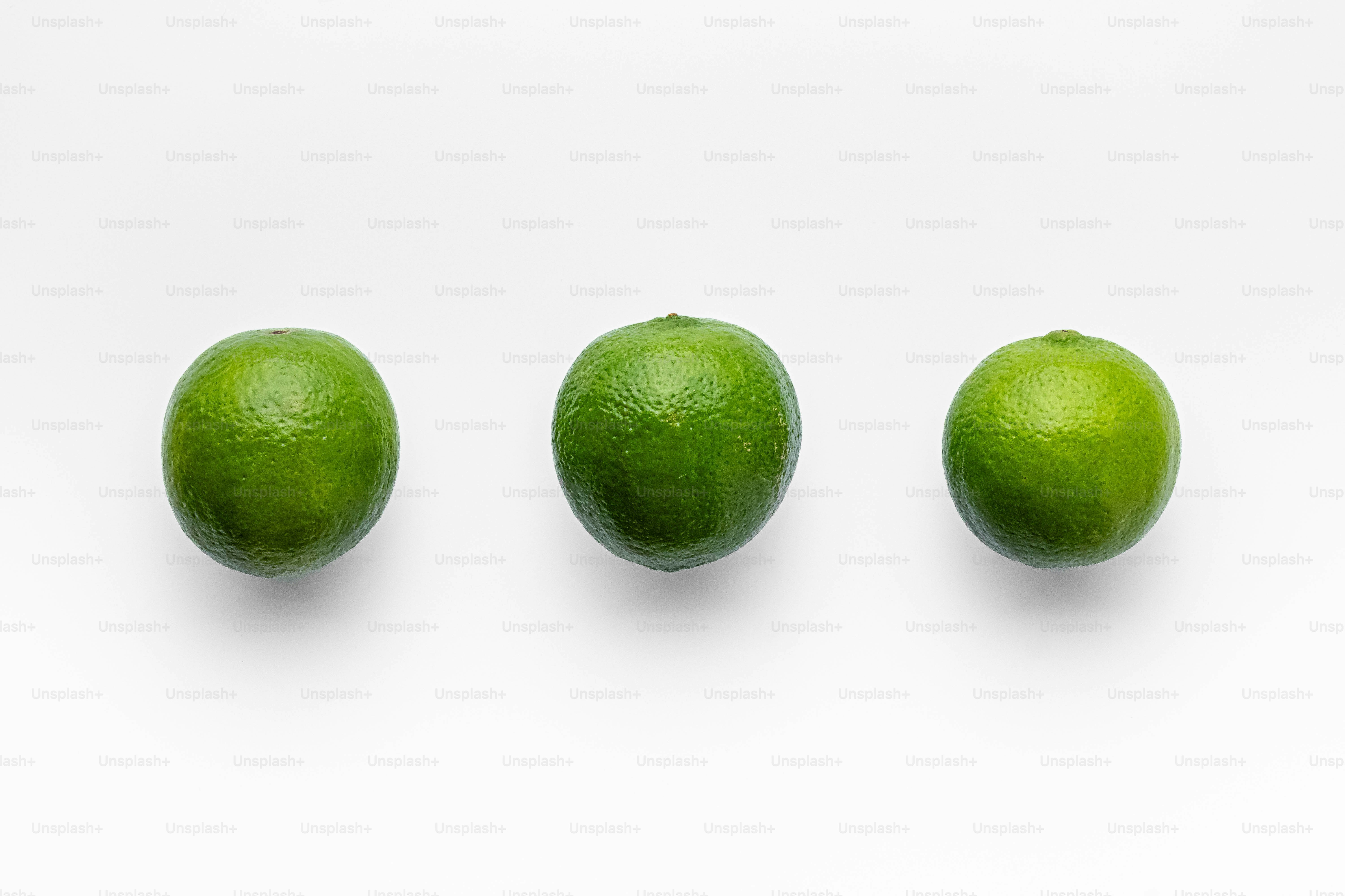 A group of three limes sitting next to each other