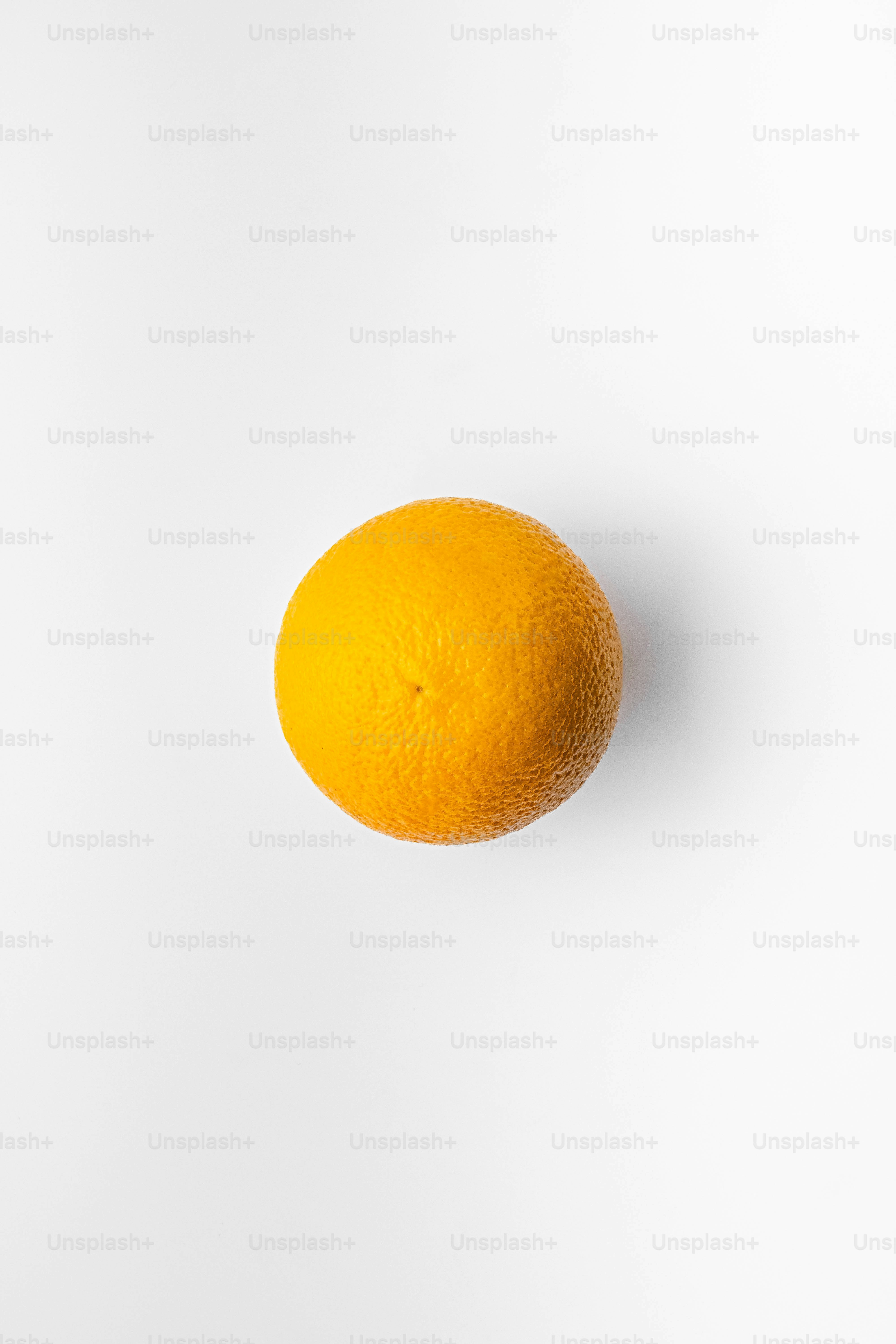 An orange sitting on top of a white surface