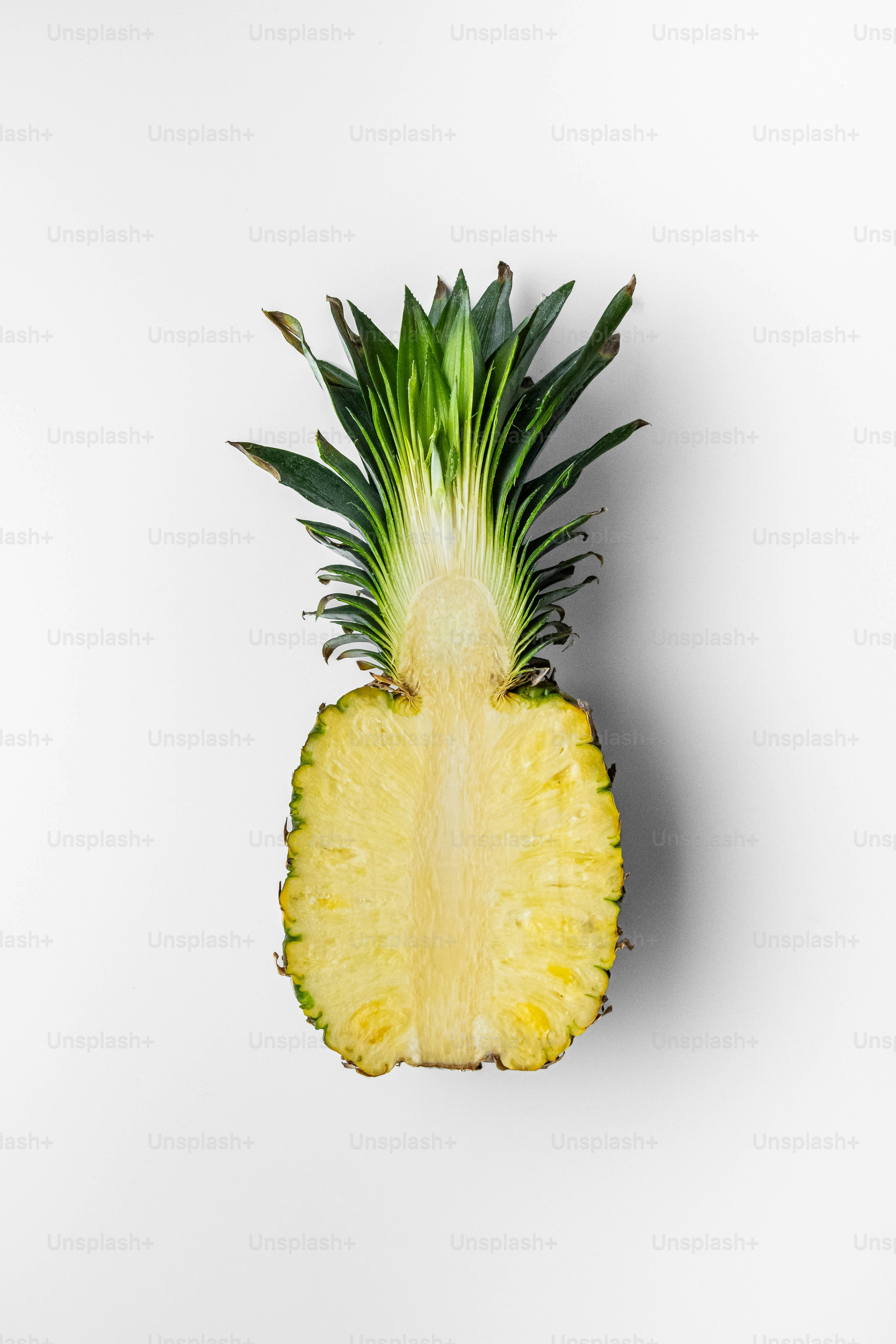Eine in zwei Hälften geschnittene Ananas auf weißem Hintergrund