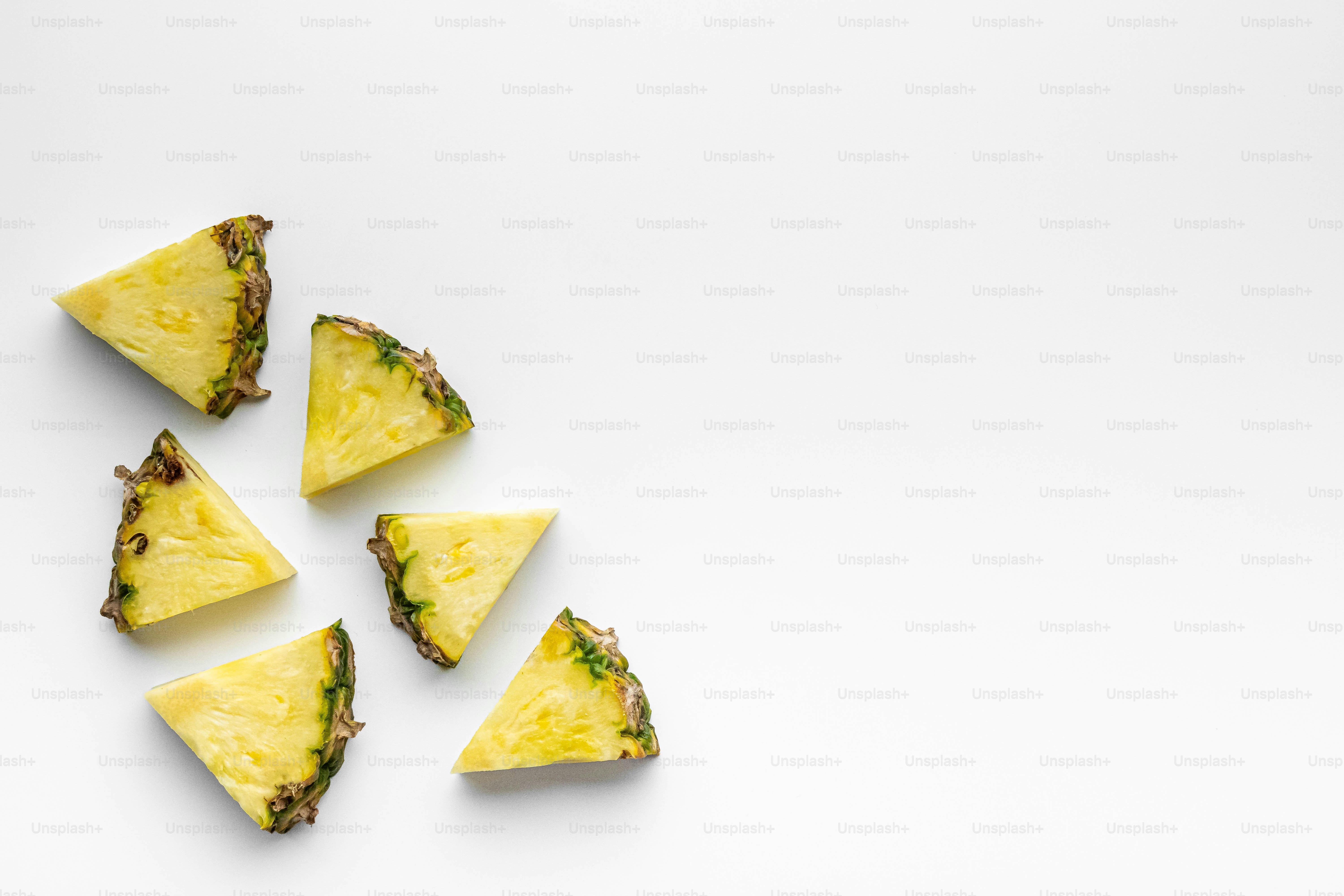 A group of pieces of pineapple on a white surface
