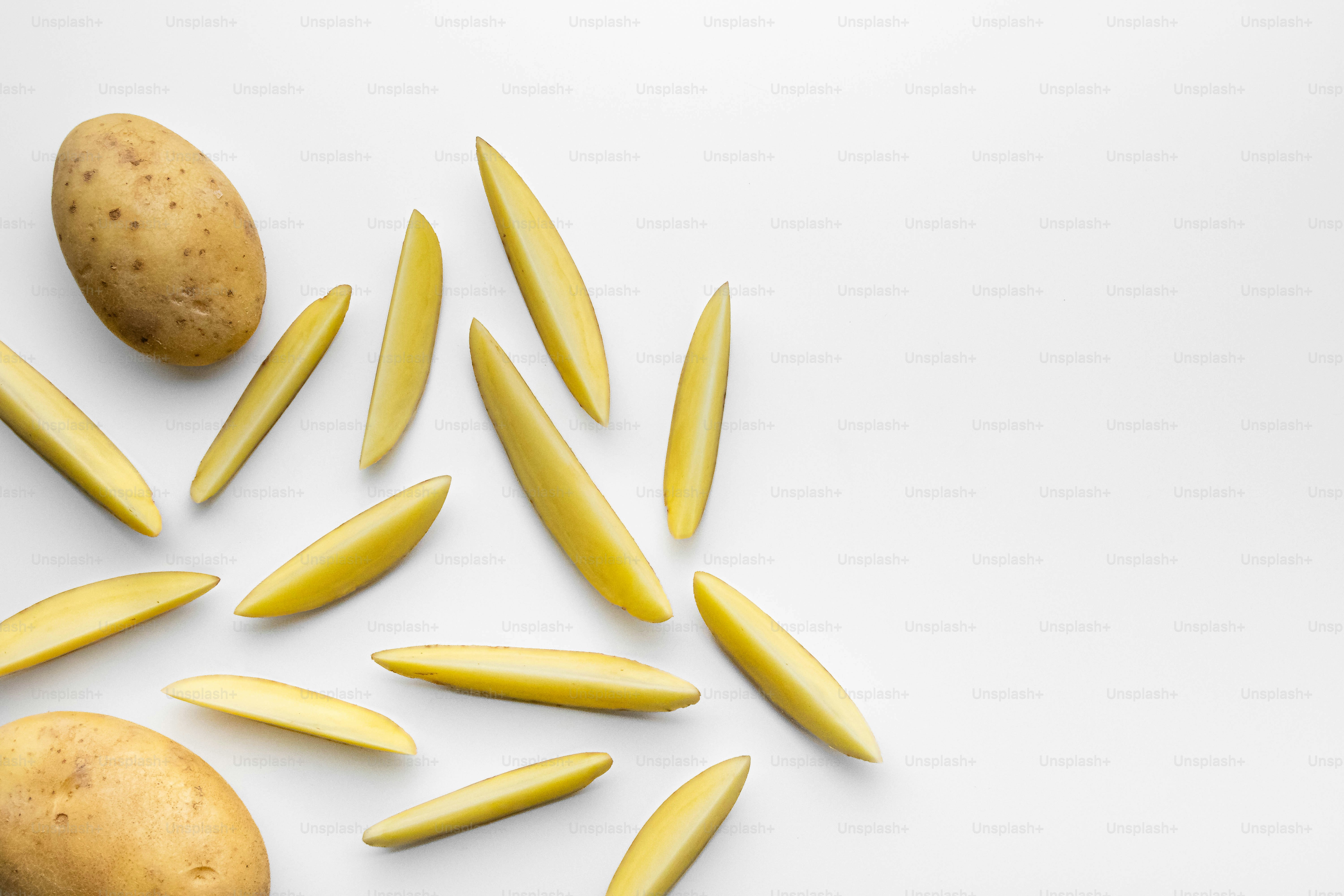 A pile of potatoes and a potato on a white background