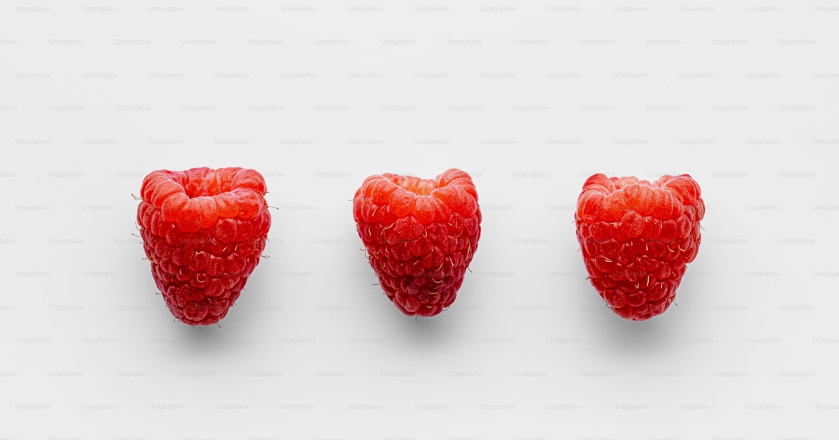 Four strawberries arranged in a row on a white background photo – Food ...